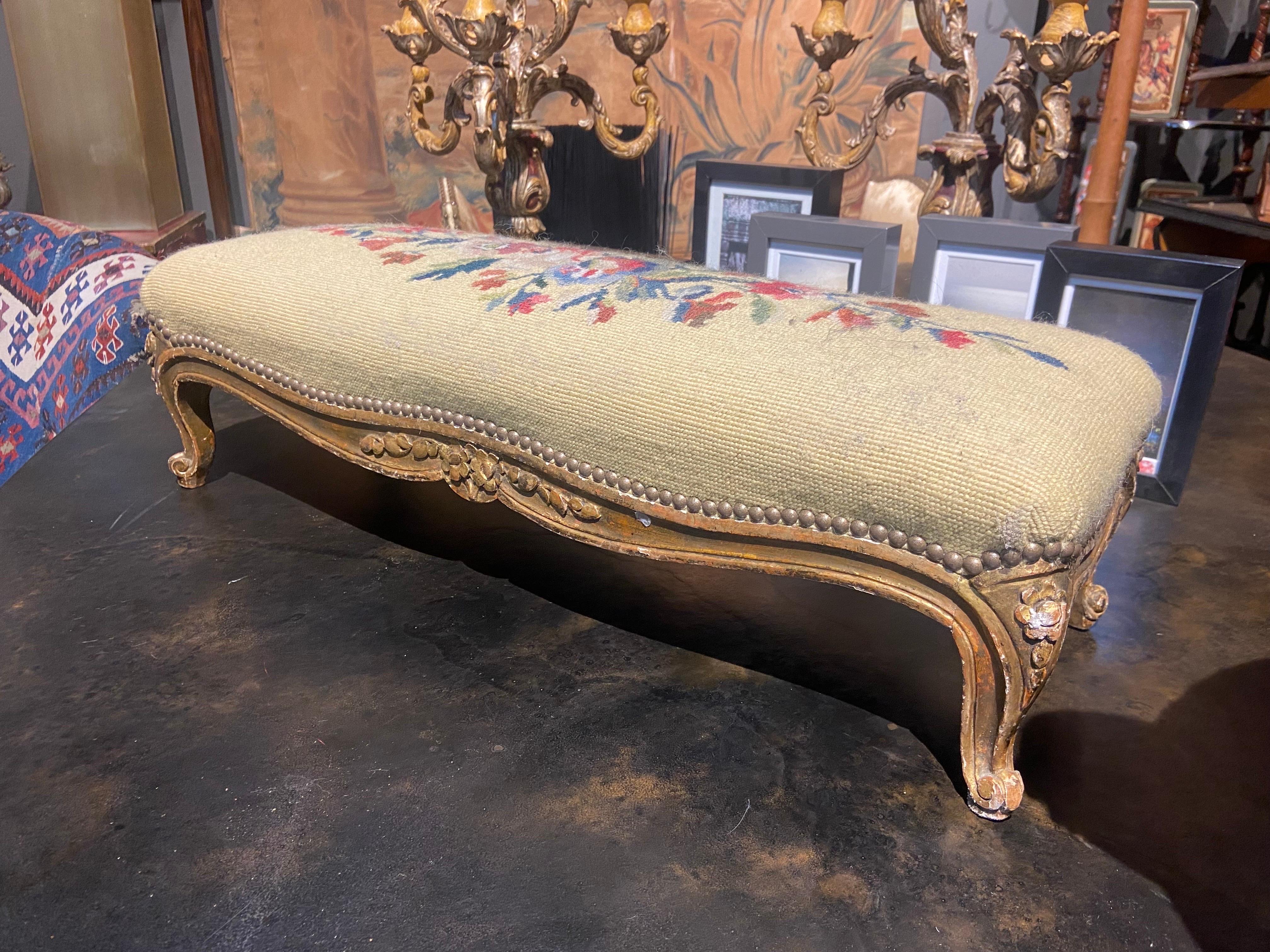 Beautifully executed with fine attention to details, French Louis XV style carved gilt wood stool on cabriole legs ending with snail feet, decorated with foliage and with original needlepoint tapestry.
France, circa 1860