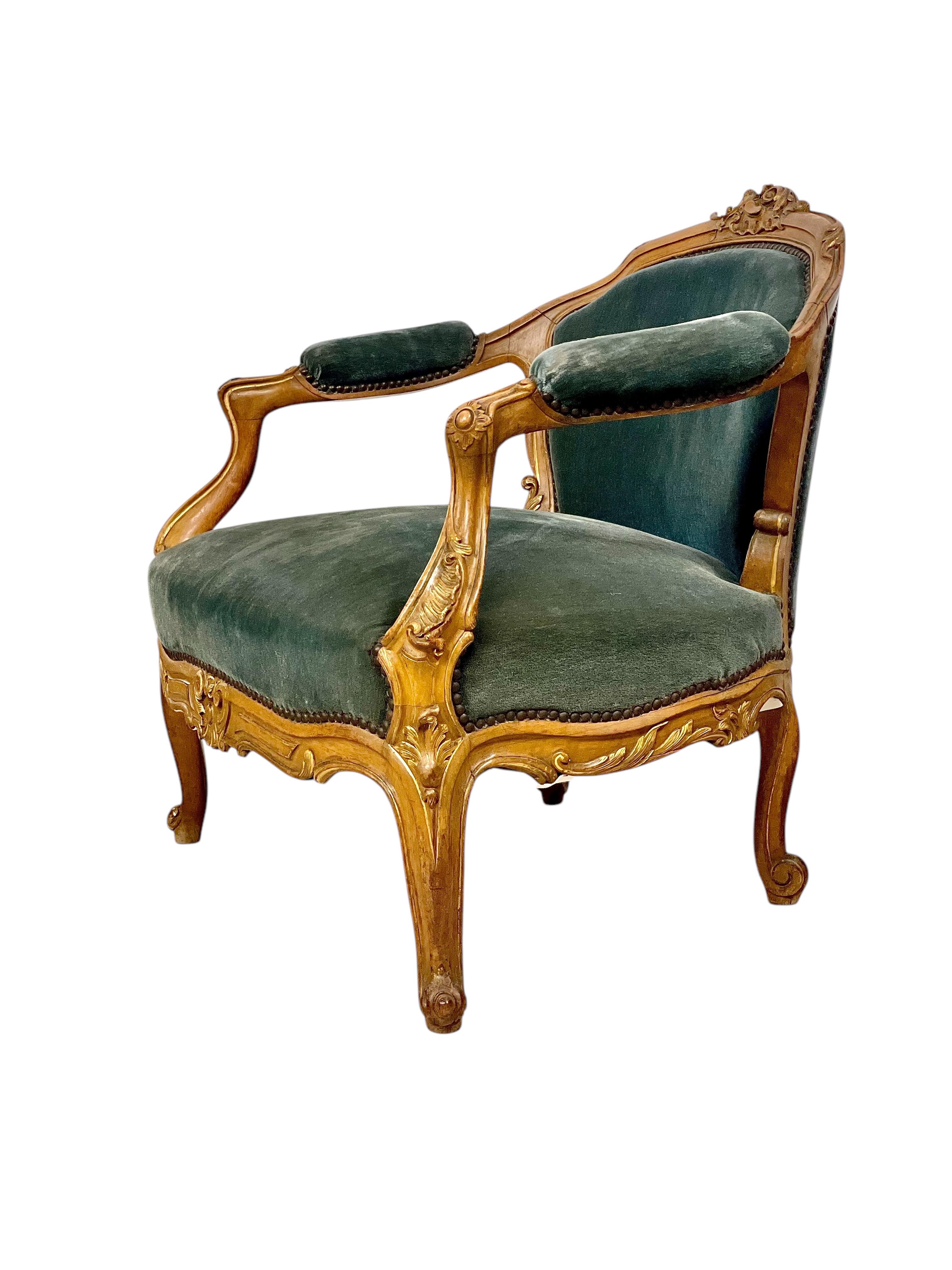 This exquisite 19th-century Louis XV-style bergère armchair embodies timeless French elegance and craftsmanship. The frame is beautifully carved in solid giltwood, featuring intricate floral and scroll motifs across the crest rail, arms, and legs.
