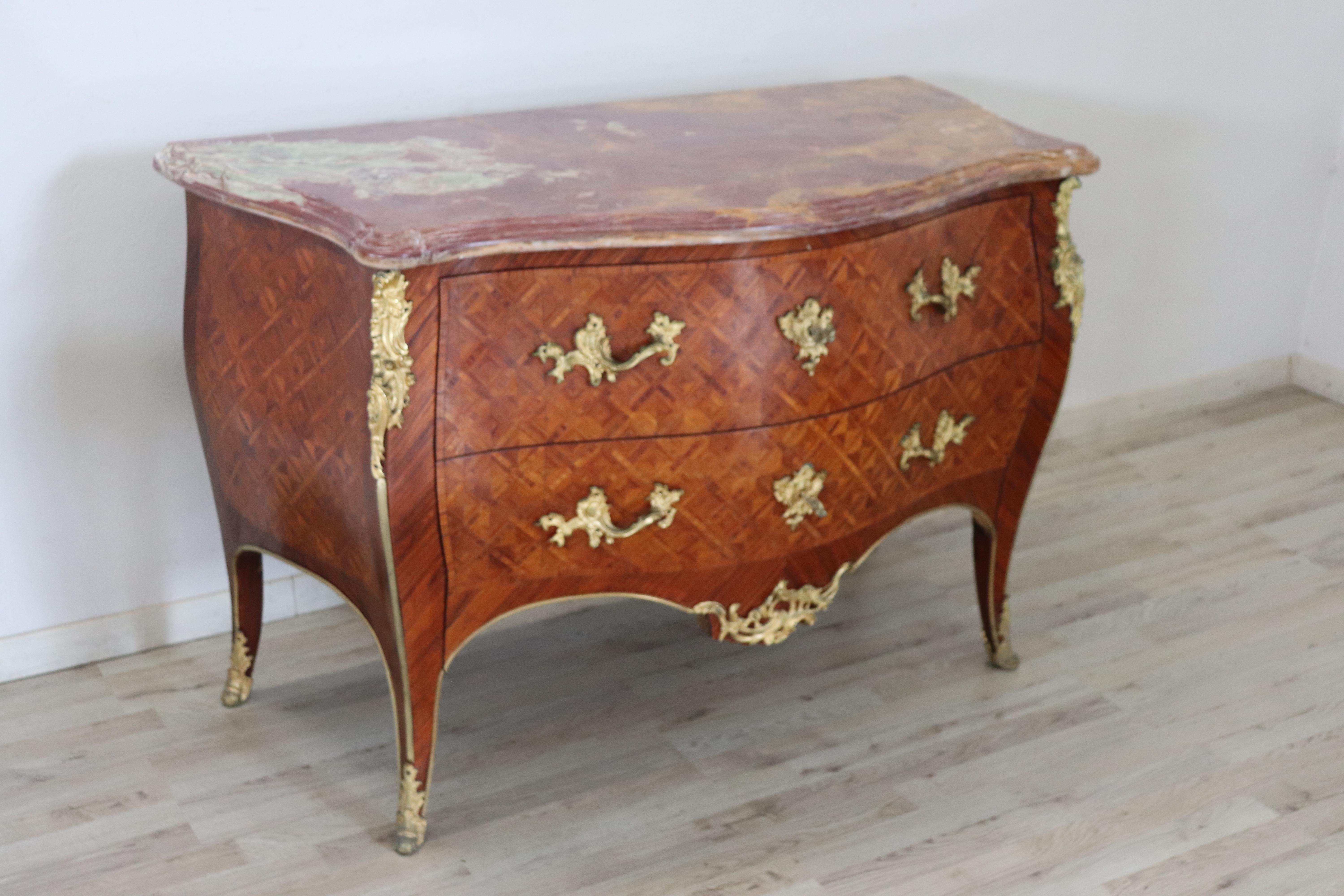 Spectacular antique French chest of drawers in precious rosewood. The line is typical of the Louis XV style with elegant wavy legs. Rich decoration in finely chiseled gilded bronze makes this chest even brighter. The particular rounded front has two