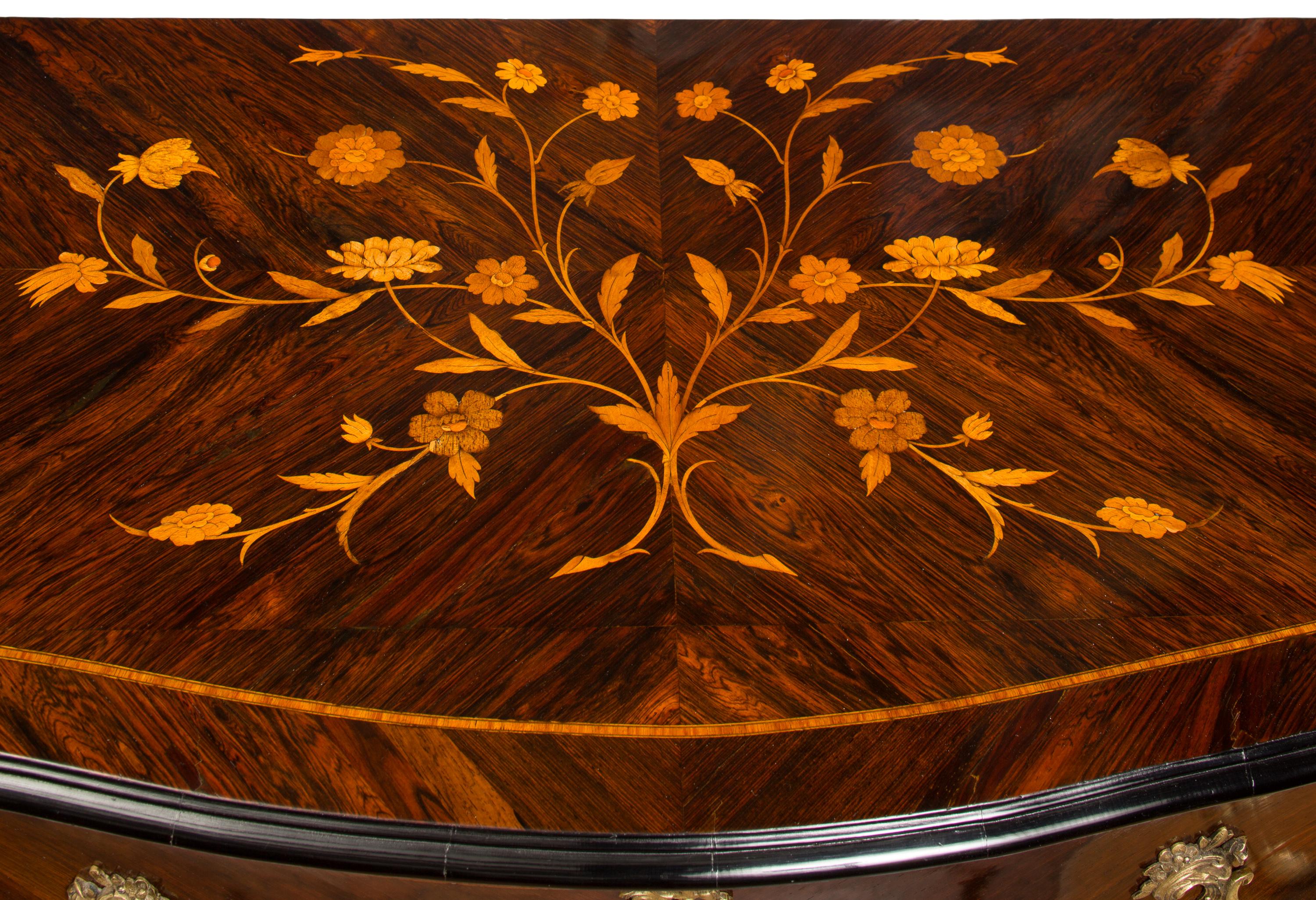 Questa commode francese del XIX secolo, in stile Luigi XV, presenta intarsi in legno multipli molto dettagliati, tra cui un grande disegno floreale sul piano, che è degno di nota, dato che molte commodes di questo stile hanno il piano in marmo.