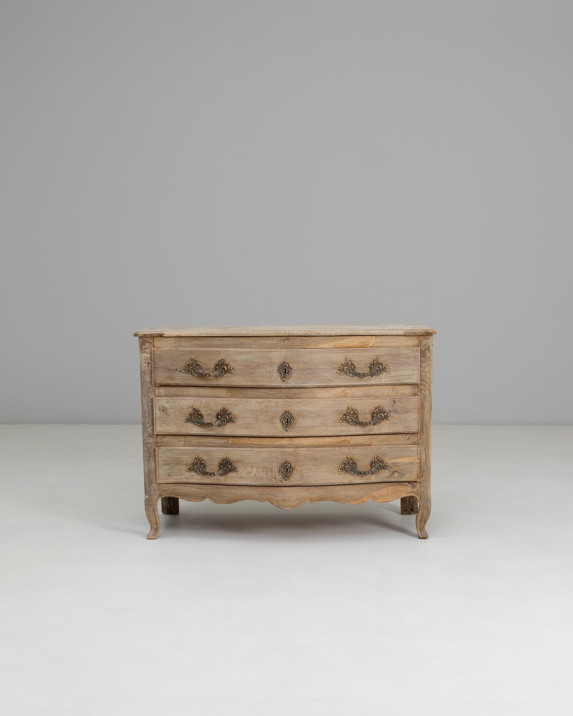 19th Century French Louis XV Style Oak Chest of Drawers. This beautifully shaped chest embodies the graceful curves and refined ornamentation characteristic of the Louis XV style. Crafted from solid oak, it features three serpentine-front drawers