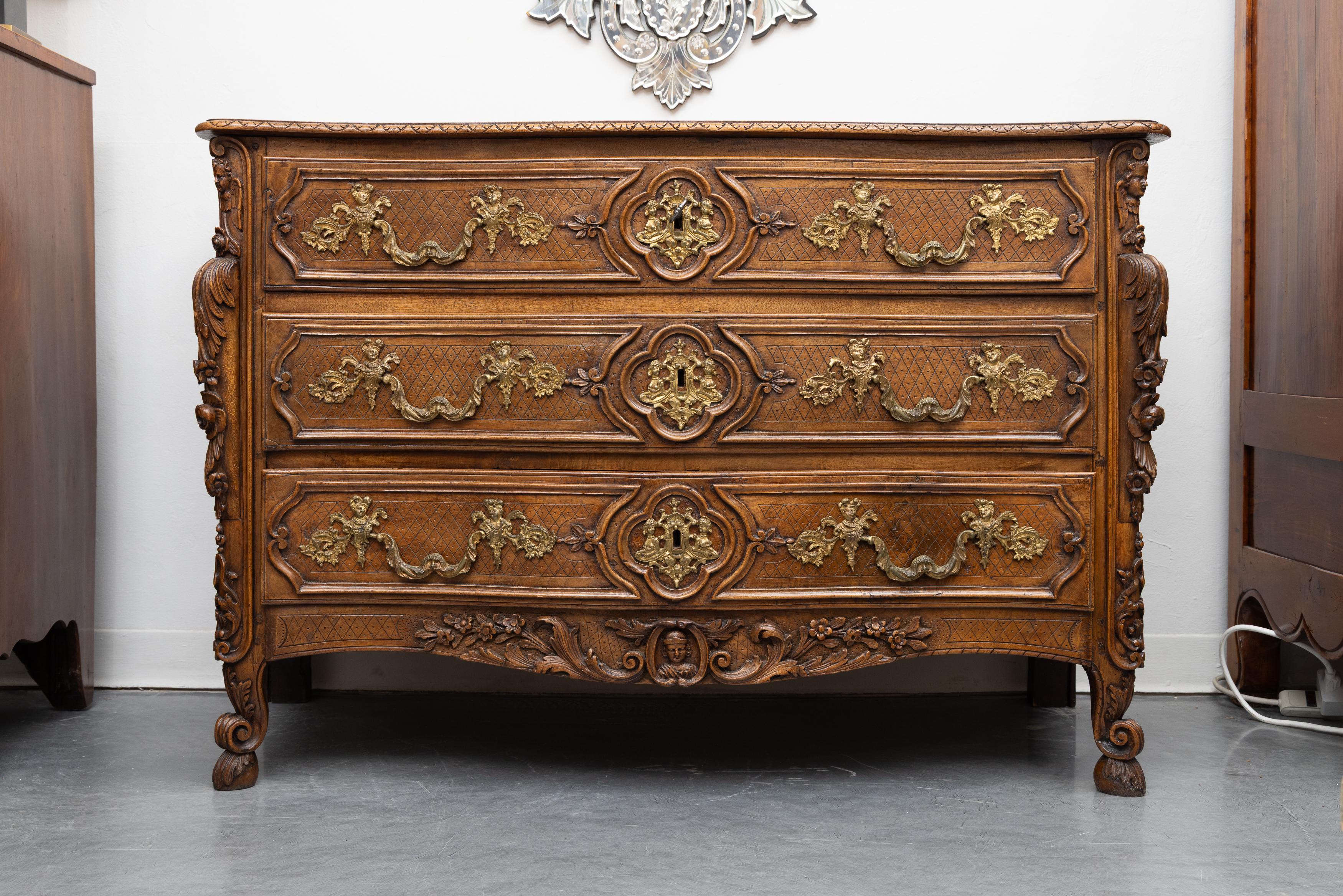 Il s'agit d'une exceptionnelle commode en chêne Louis XV du début du XIXe siècle. Le plateau est gravé de volutes décoratives et centré d'une croix de Bolnisi incrustée de bois de rose. La commode contient trois tiroirs lourdement sculptés avec des