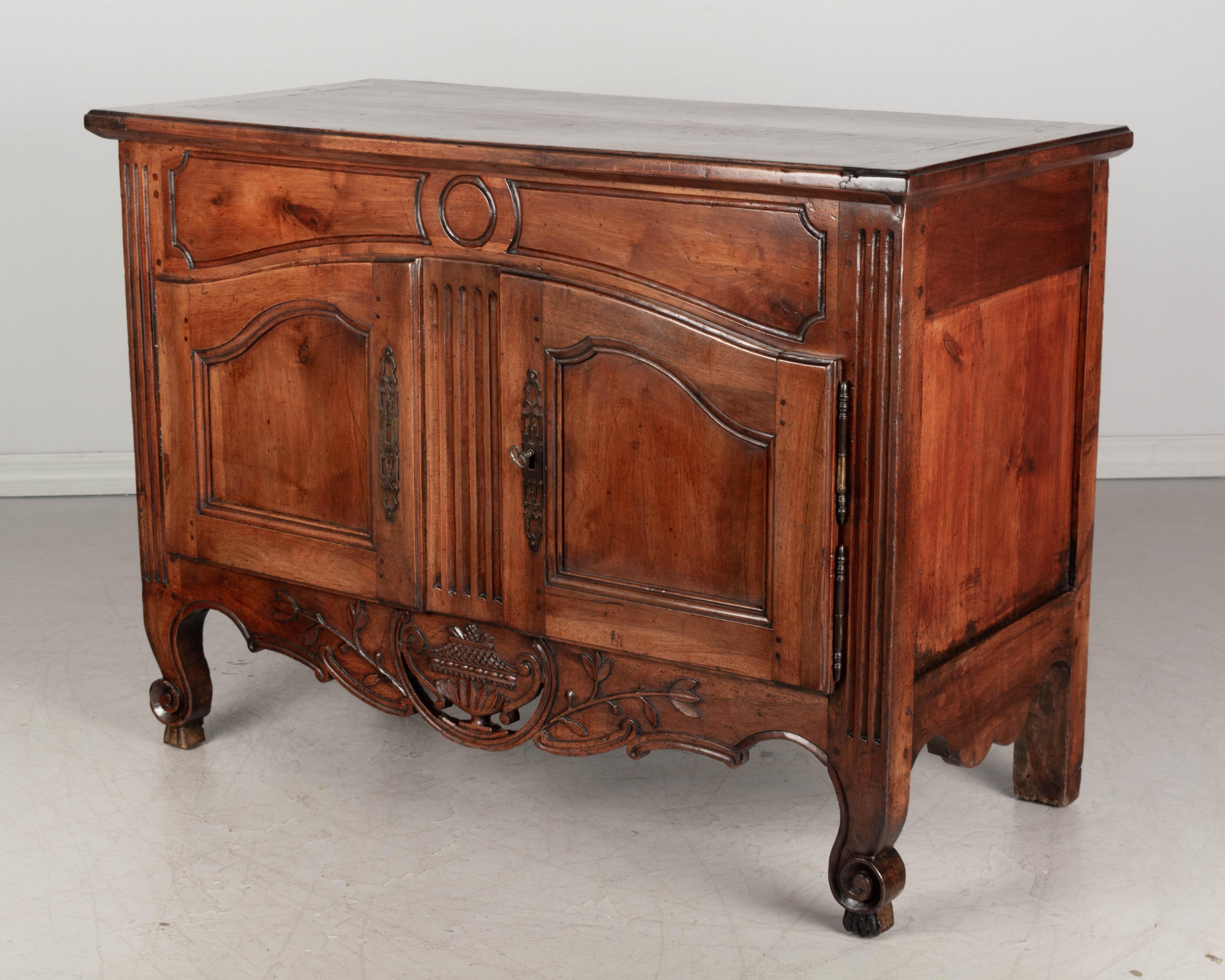 A fine early 19th century Louis XV style Provençal buffet made of solid walnut. Beautiful hand carved pierced apron and large scrolled toes. Good craftsmanship with nice proportions, providing ample storage. This buffet originally held a large dough