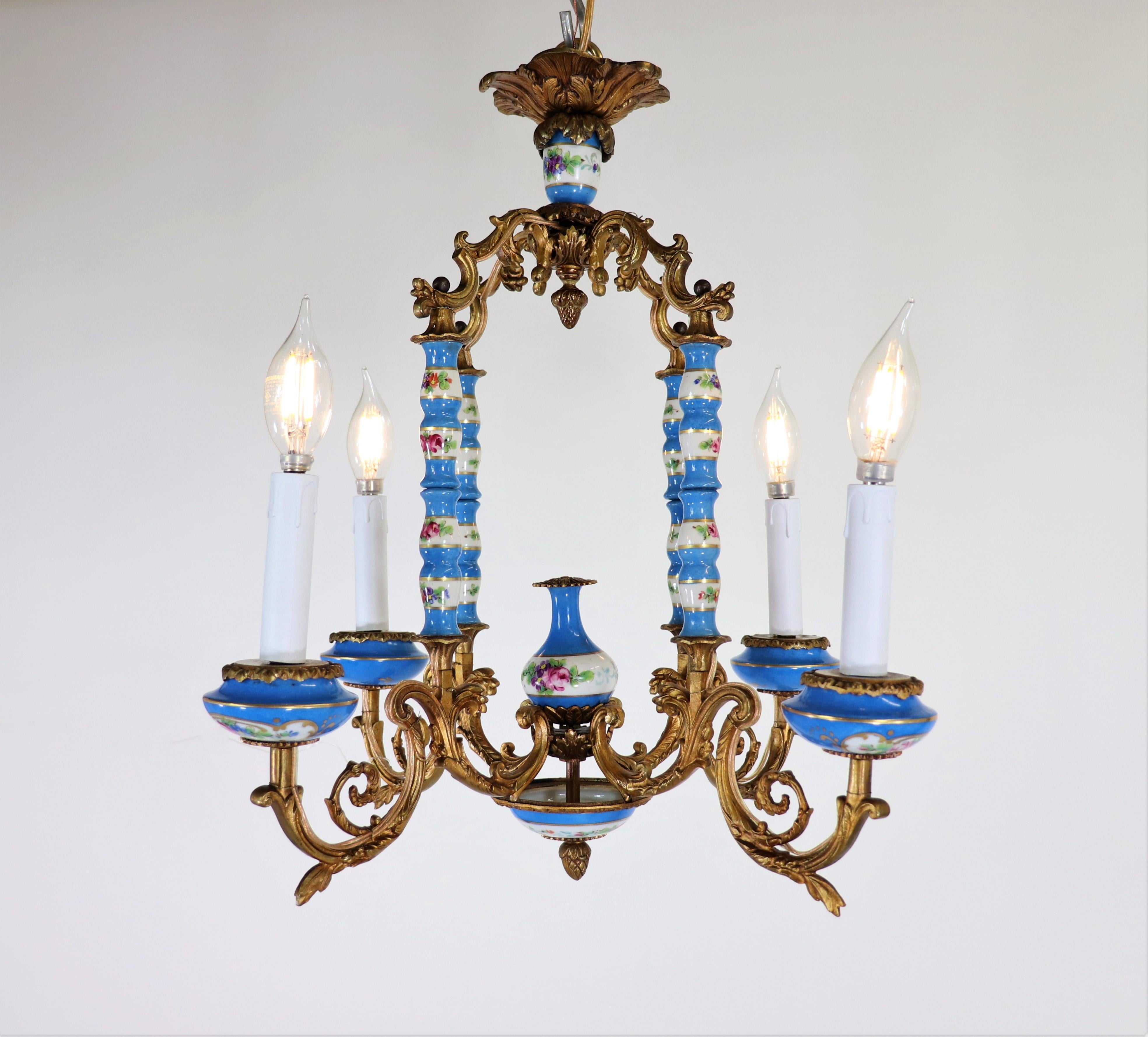 Questo squisito lampadario francese del XIX secolo in stile Luigi XV è una testimonianza dell'opulenza e della maestria dell'epoca, realizzato con la rinomata porcellana di Sèvres e montato in una lussuosa struttura in bronzo dorato. L'esclusiva