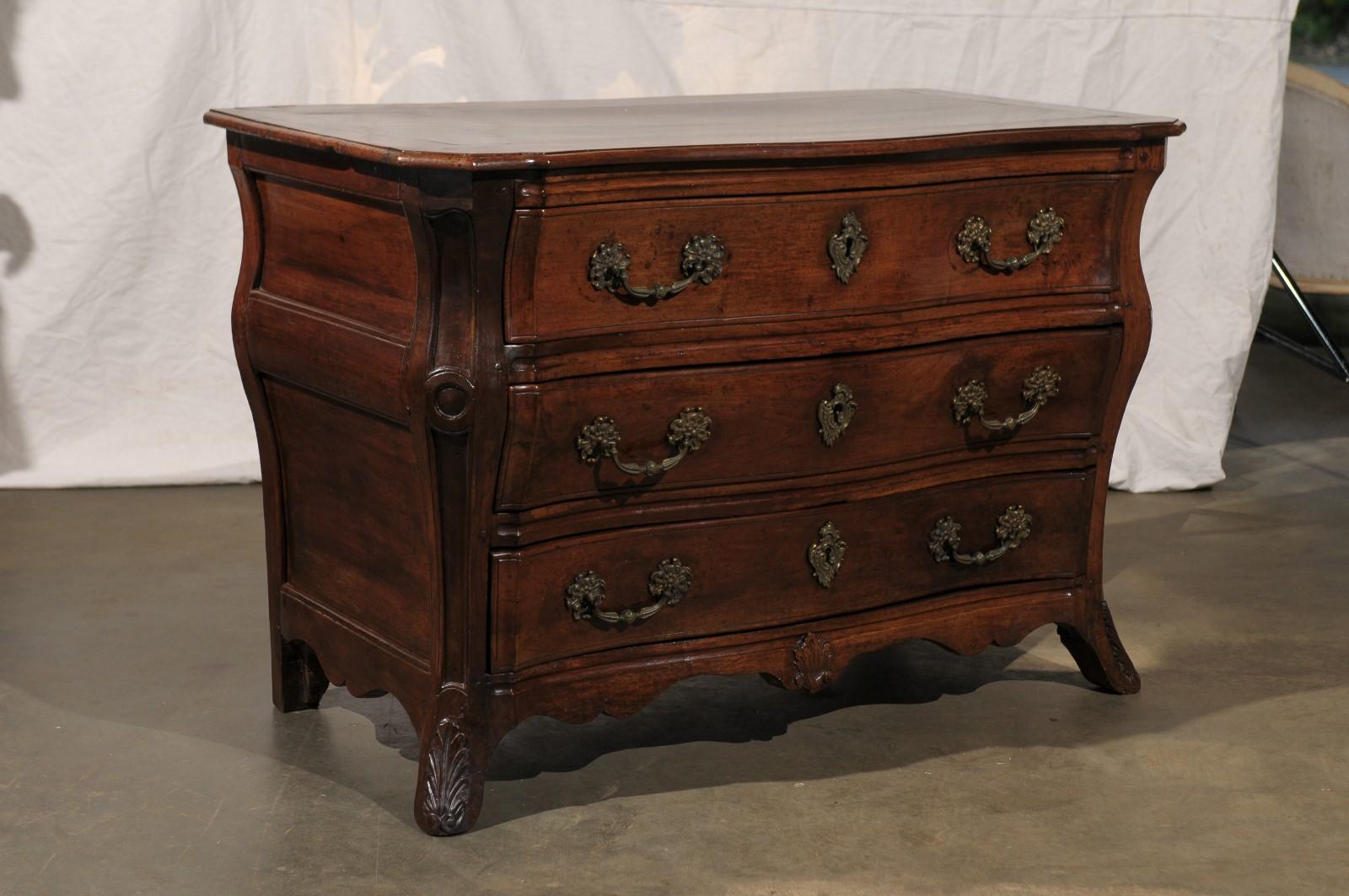 19th century French Louis XV style walnut commode with carved details.