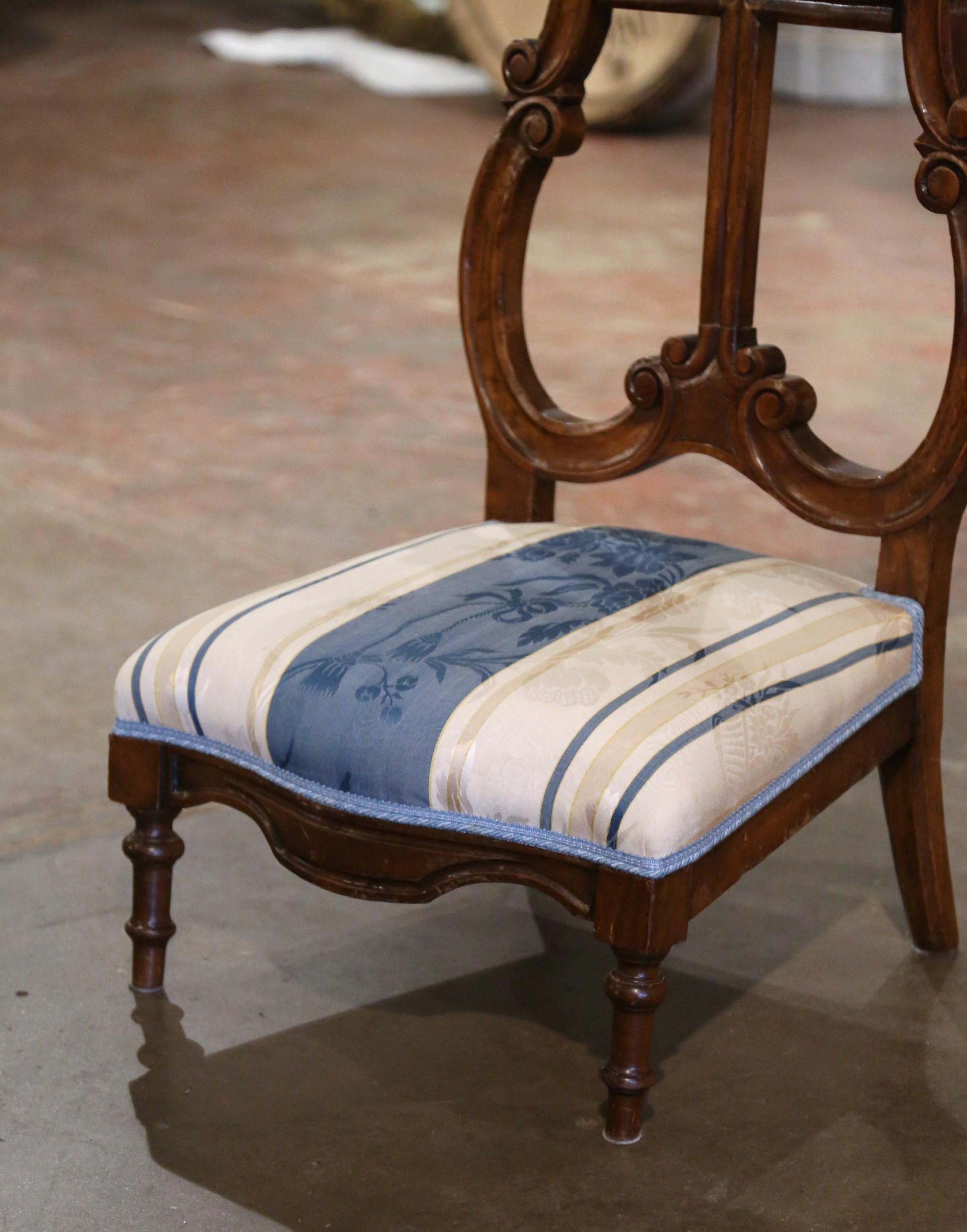 Placez cette élégante chaise de prière antique dans une chambre à coucher pour vos dévotions quotidiennes. Fabriqué en France, vers 1960, cet agenouilloir traditionnel en noyer repose sur des pieds tournés au-dessus d'un tablier en bombe festonné.
