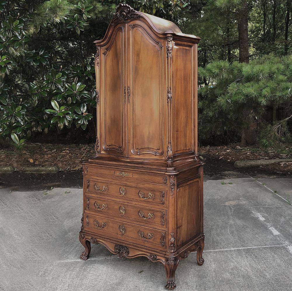 19th century French Louis XV walnut cabinet, commode boasts a boldly arched crown carved with shell motif overlooking the beautiful natural wood grain of the sumptuous French walnut door panels below. The upper cabinet rests on a full sized commode