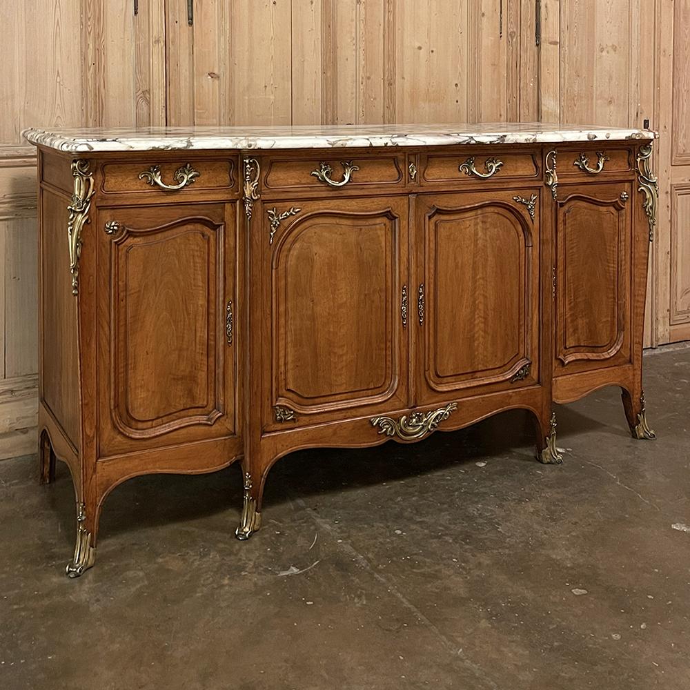 19. Jahrhundert Französisch Louis XV Nussbaum Marmor Top Buffet mit Ormolu ist ein atemberaubendes Beispiel für die raffinierte Interpretation des Stils!  Das elegante Fachwerk zeichnet sich durch seinen hellen Nussbaumton, das Noyer-Blond, sowie