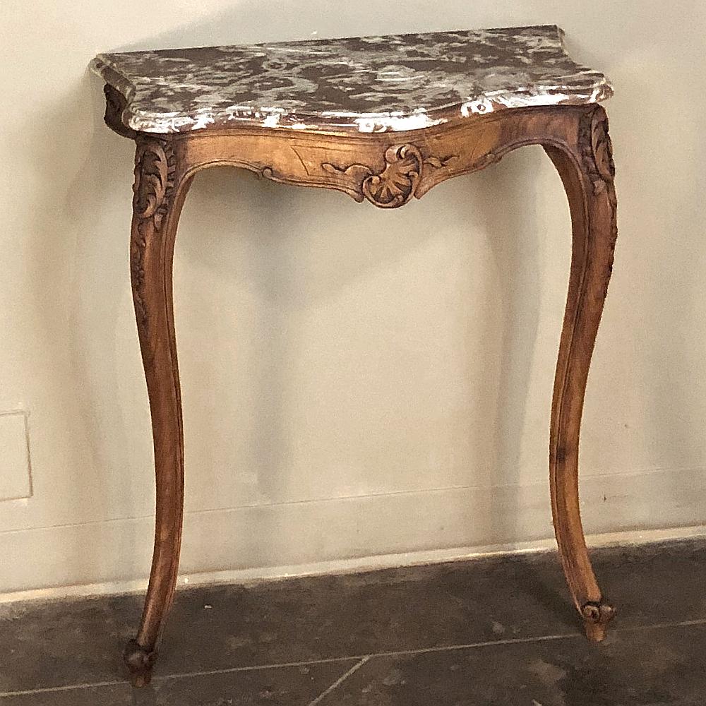 19th Century French Louis XV Walnut Marble Top Console features timeless elegance with its definitive naturalistic form expressed in the graceful cabriole legs, bombe apron form with serpentine sides, and hand-carved shell and foliate embellishment