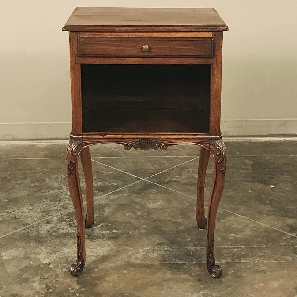 19th century French Louis XV walnut nightstand ~ end table is remarkable in that it's carved on all four sides with wonderful Rococo motifs, making it a good choice for a seating group in the middle of the room, or as a charming bedside companion!