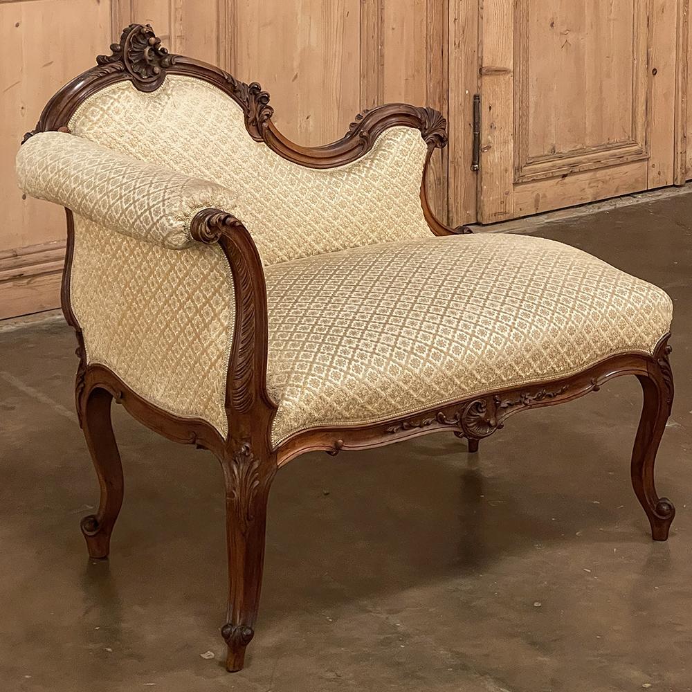19th Century French Louis XV walnut petite chaise lounge is the perfect choice for adding incredible French flair in a diminutive, cozy spot! Sculpted from sumptuous French walnut, the framework exhibits the naturalistic, asymmetrical scrollwork
