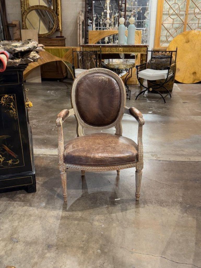 Buona poltrona francese Luigi XVI del XIX secolo intagliata e dipinta con pelle. Circa 1880. Un tocco classico e senza tempo per un interno raffinato. 24 l x 24 p x 36 h