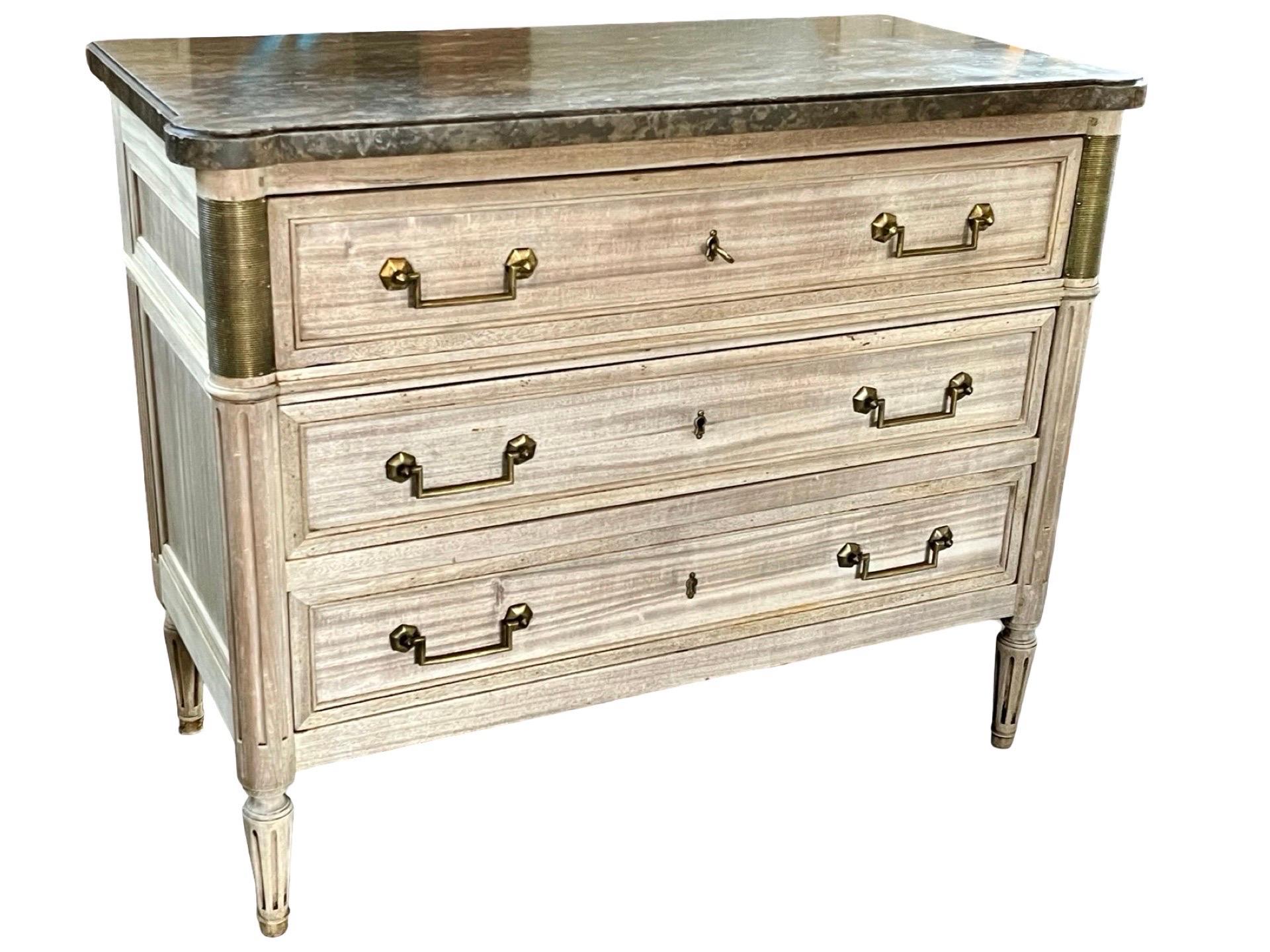 Louis XVI commode with secretaire hand-crafted in France using mahogany and pegged construction. The commode features three inset drawer, the first of which slides out to reveal a small writing surface and three smaller drawers. The writing surface