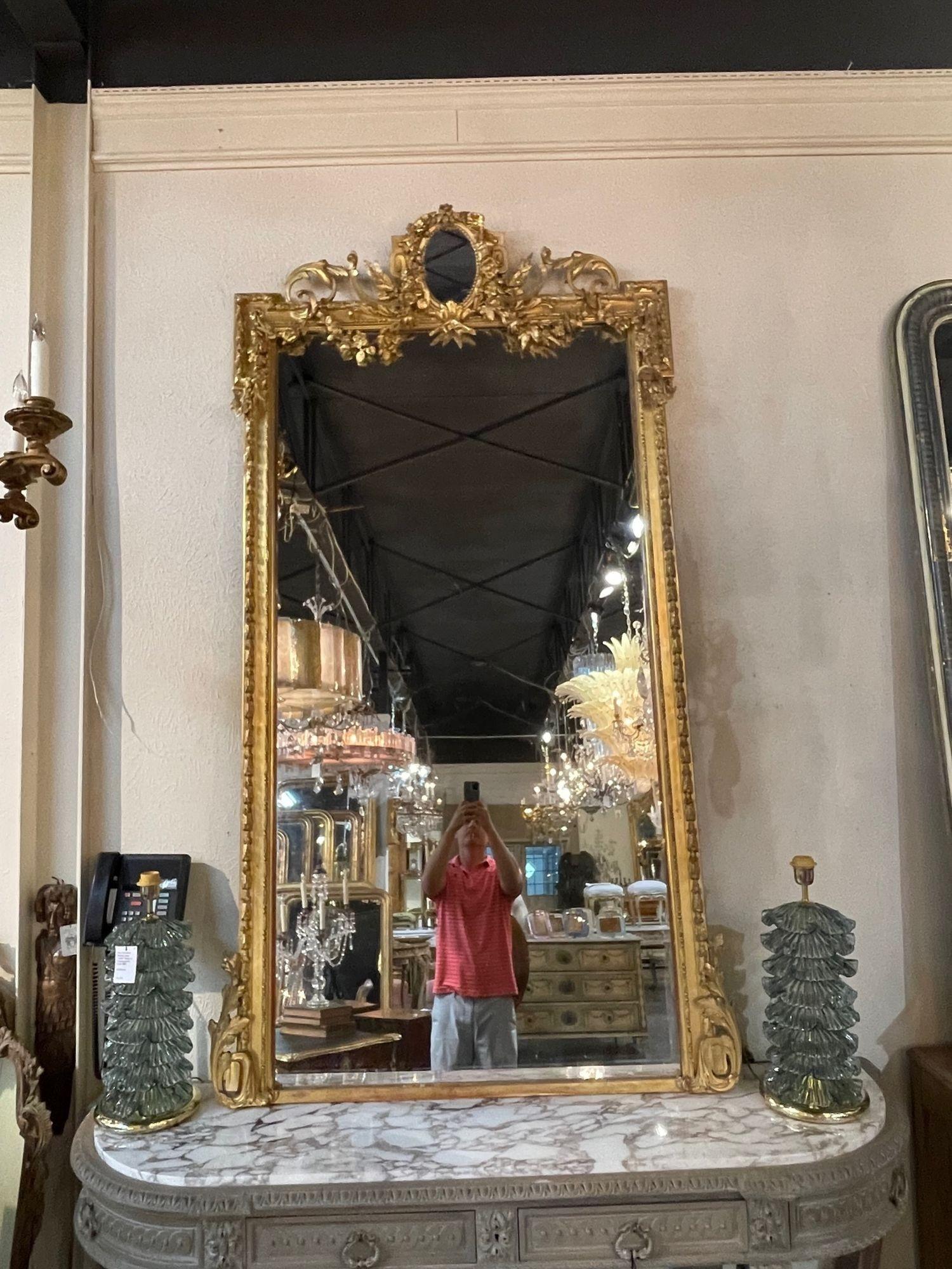 Elégant miroir Louis XVI de grande taille, datant du XIXe siècle, en bois sculpté et doré. Les sculptures sont très fines, avec de belles fleurs et des feuilles, et un petit miroir au sommet. Une pièce vraiment exceptionnelle ! Très impressionnant !