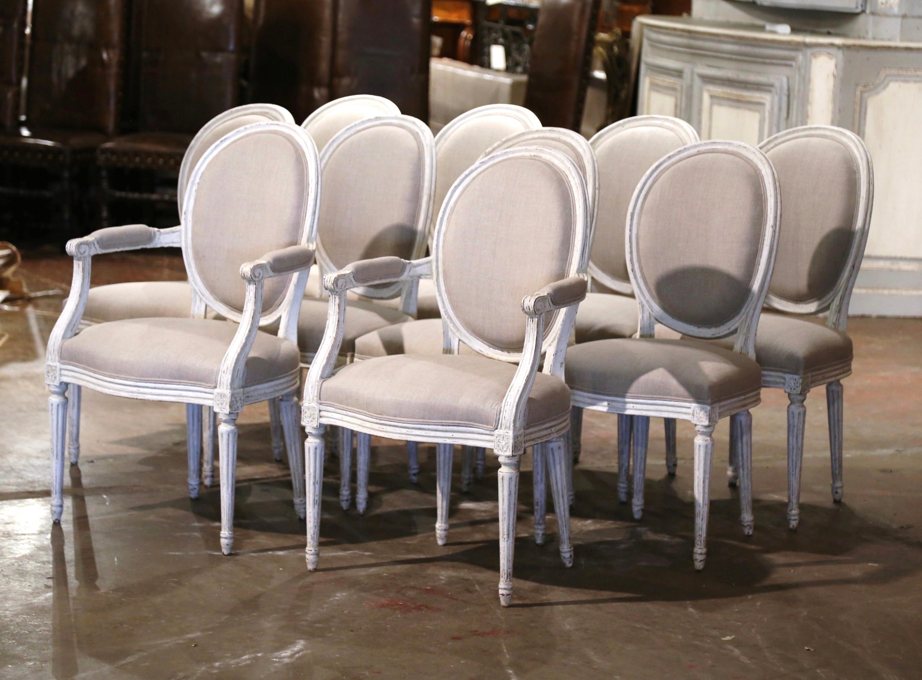 Dressed a dining table with this elegant suite of antique dining room chairs. Crafted in France, circa 1890, the set comprises 8 sidechairs and two matching armchairs. Each chair stands on tapered and fluted legs decorated with a floral rosette