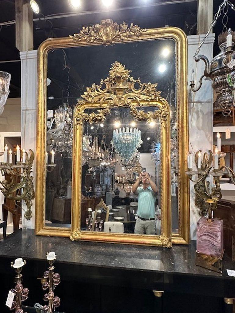 Exquisite 19th century French Louis XVI carved and giltwood mirror. Featuring a gorgeous elaborate crest at the top with an urn with leaves and flowers. Stunning!!