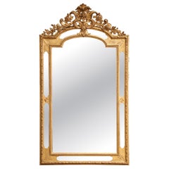 Specchio francese Luigi XVI del XIX secolo in legno dorato intagliato con stemma floreale