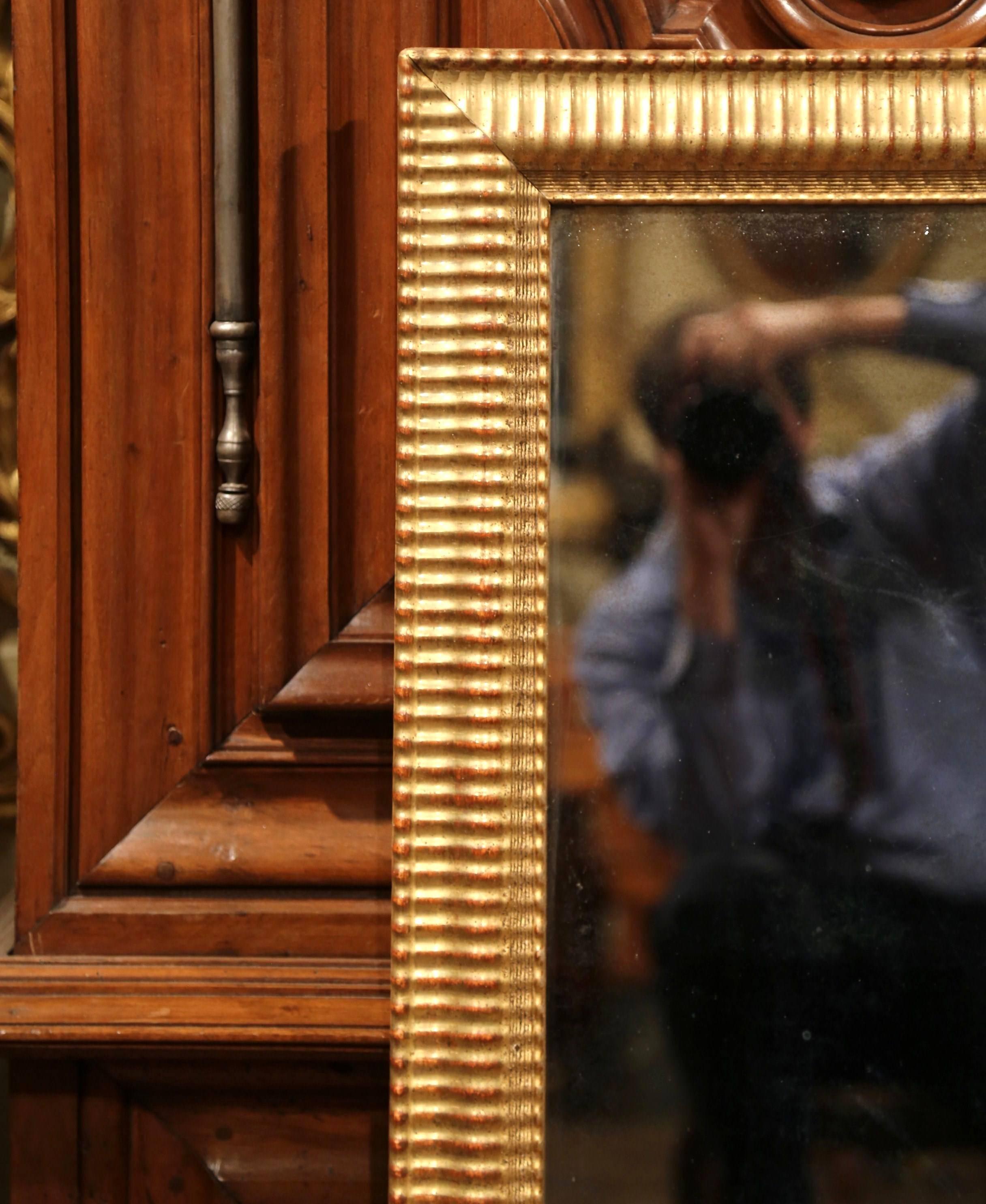 Place this versatile antique wall gilt mirror horizontally over a buffet, or vertically in a powder room. Crafted in France, circa 1860, the large, rectangular, wooden frame with gold leaf is embellished with carved stripe decor around the frame,