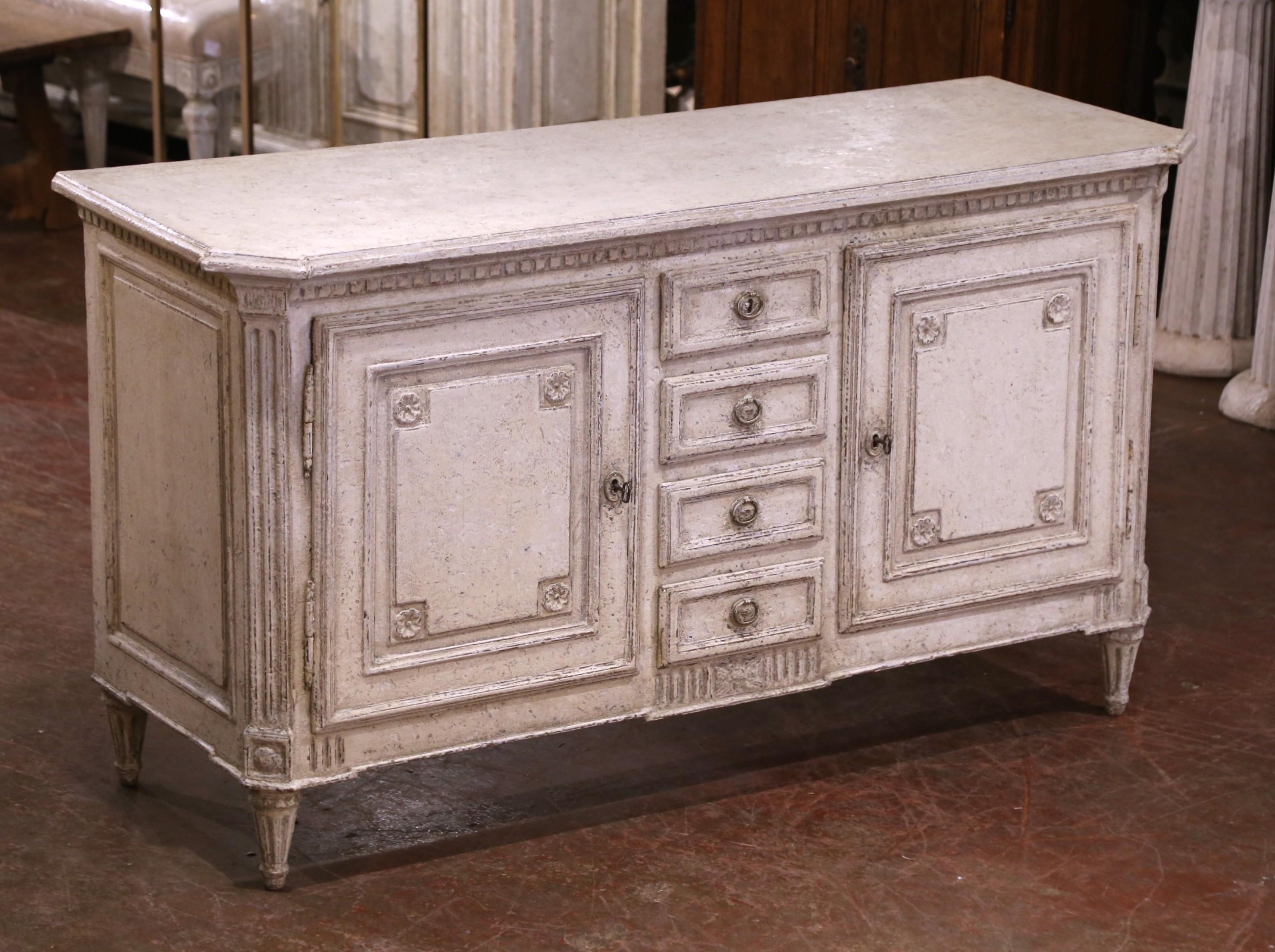 Porta l'eleganza neoclassica e il fascino rustico nella tua sala da pranzo con questo maestoso buffet dipinto. Realizzato nel nord della Francia intorno al 1880, il pezzo presenta una silhouette rettilinea con una parte superiore sporgente e angoli