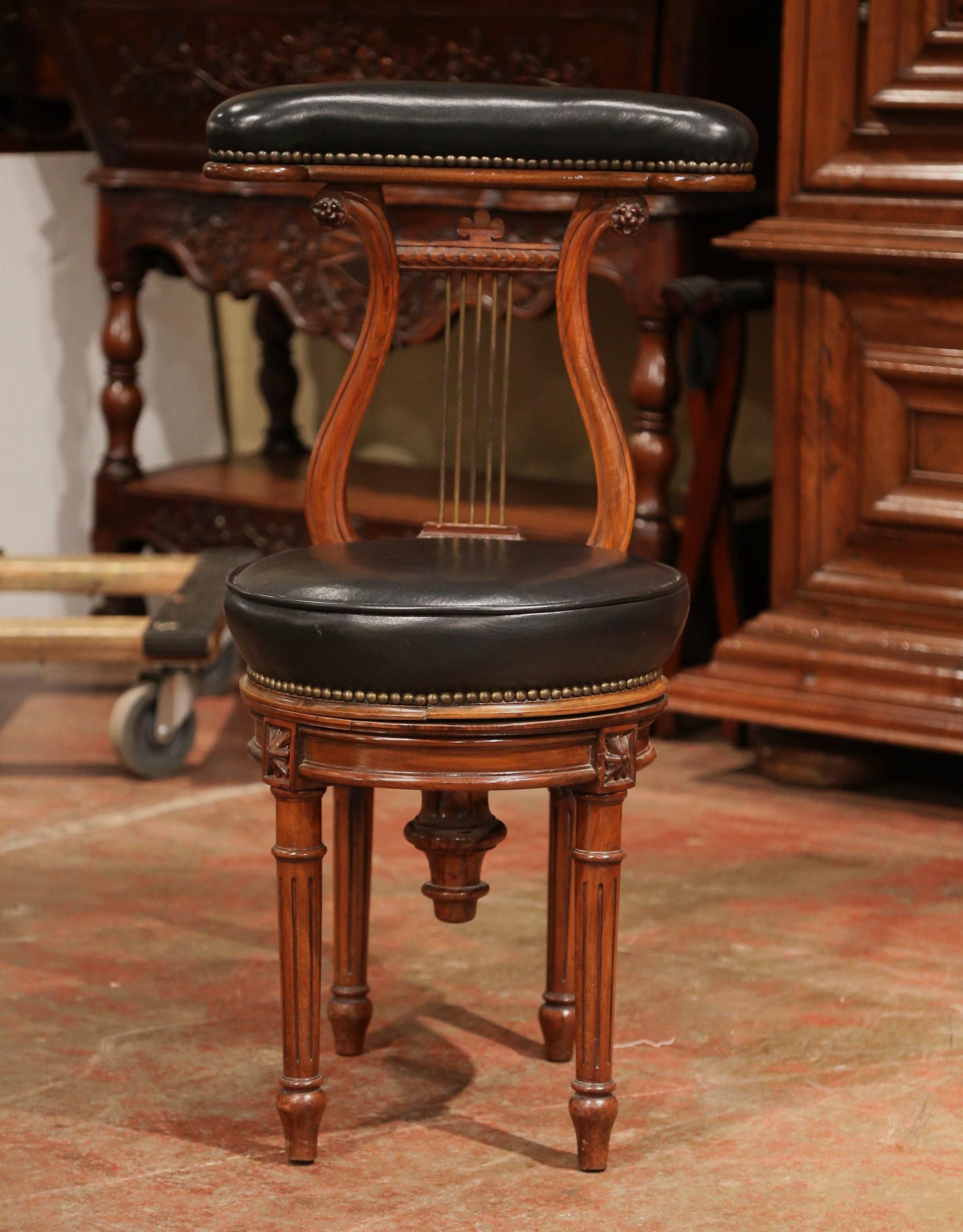 Place this elegant antique chair in a study or use it behind a piano. Crafted in Paris, France, circa 1870, the chair sits on four fluted legs embellished with carved medallions, over a adjustable swivel round leather seat; the chair features a lyre