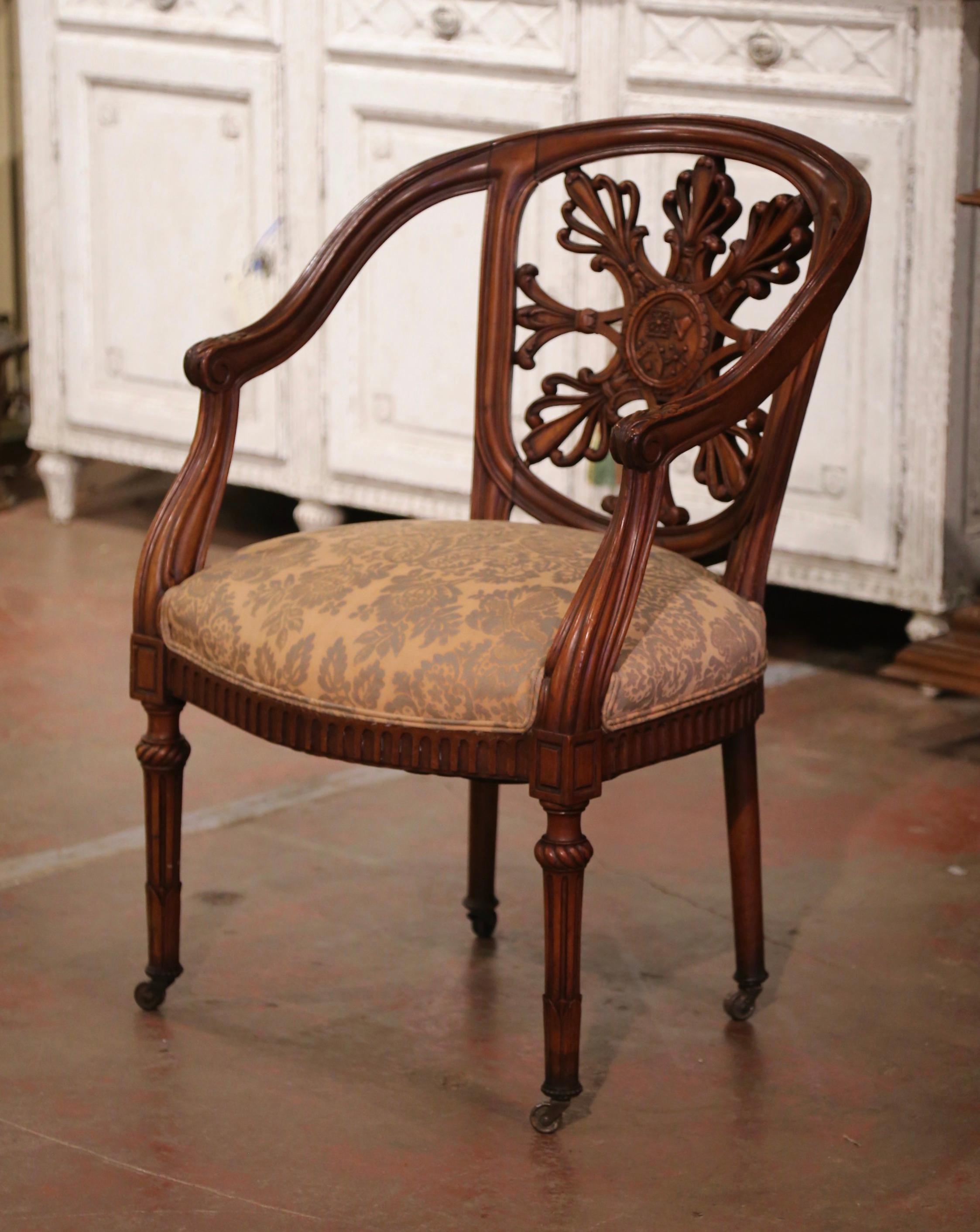 Decorate an office with this beautifully carved antique desk armchair. Crafted in France circa 1880, the fruitwood chair stands on tapered and turned legs decorated with twisted leaf motifs around the legs and ending with coasters. The comfortable