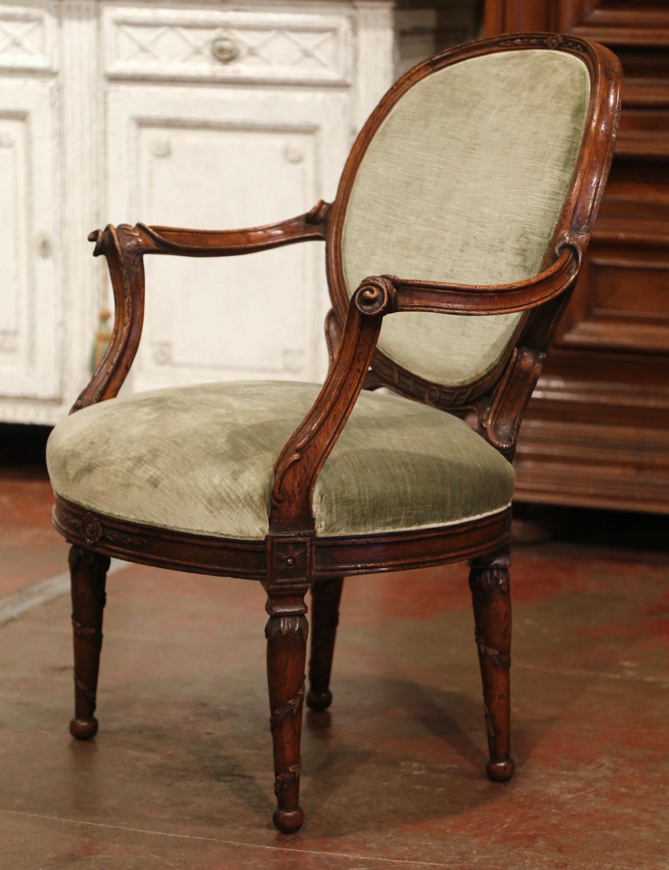 Adorn your living room, bedroom, or office with this beautifully carved antique armchair. Crafted in France circa 1880, the fruitwood chair stands on tapered and turned legs decorated with twisted leaf motifs around the legs and embellished with