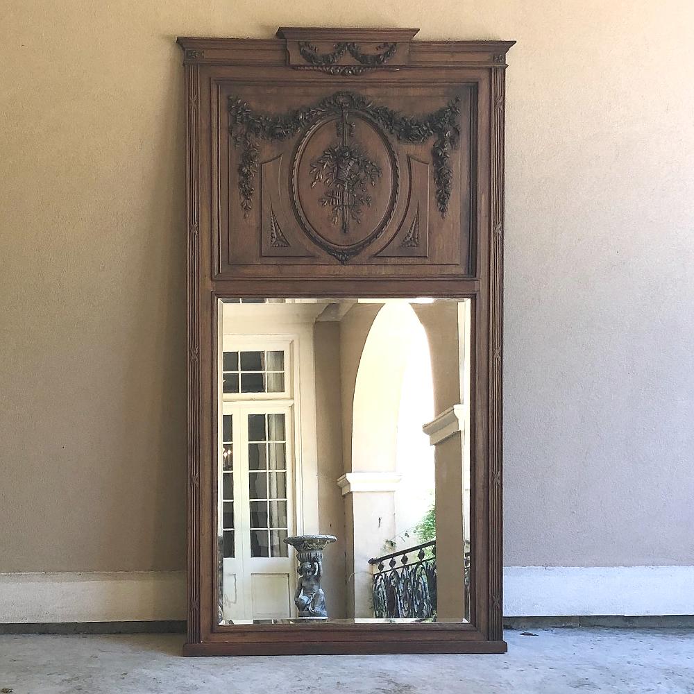 19th century French Louis XVI carved walnut Trumeau is a splendid example of the neoclassical revival of the late 1800s in Europe, where timeless designs inspired by ancient Greek and Roman art and architecture flourished on the continent,