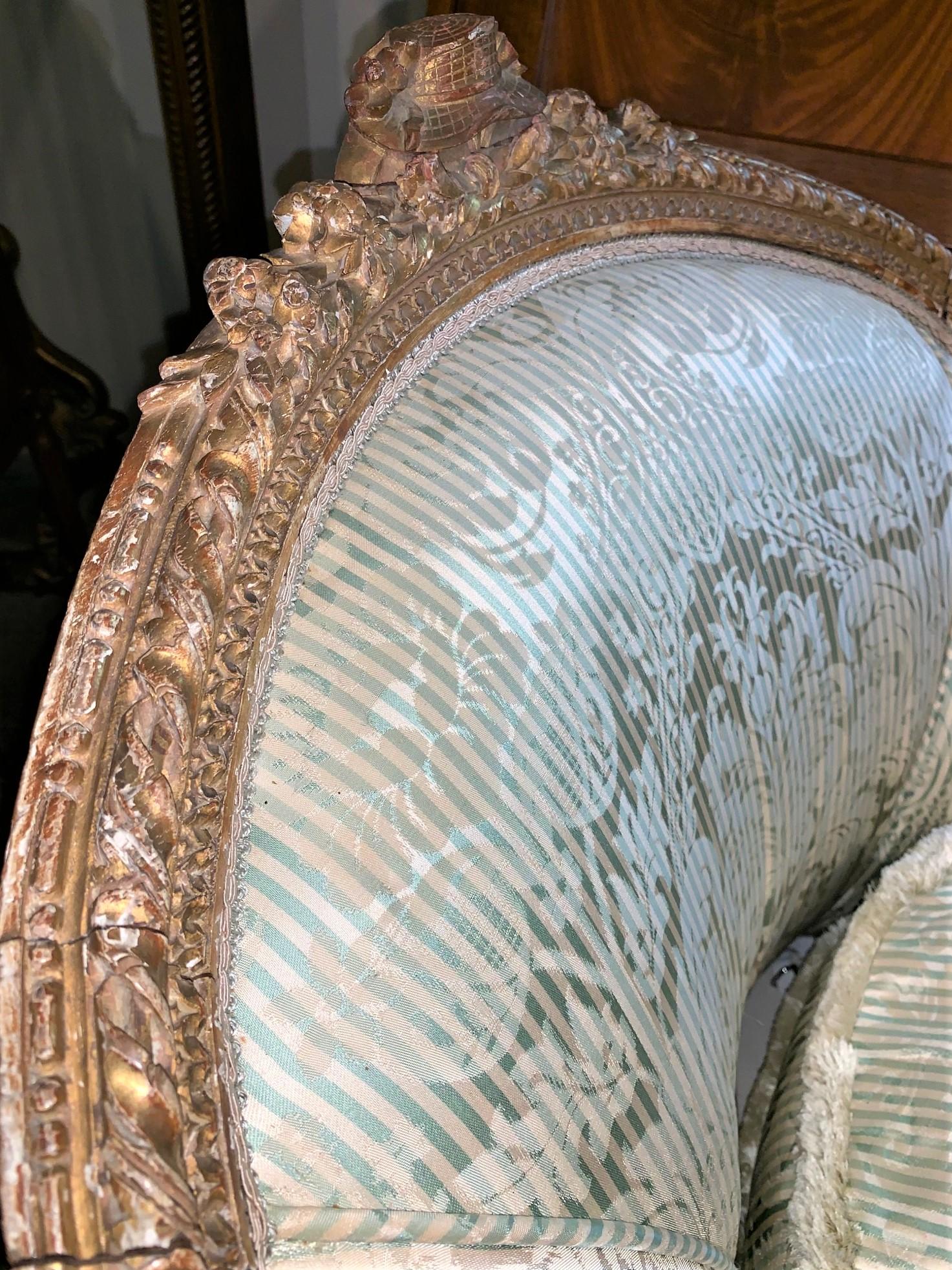 Impressive 19th French Louis XVI style chaise lounge or daybed crafted of carved giltwood. Elegant lines and nicely aged gold patina. Upholstered in silk with tear on the front cushion, (see photos),

circa 1870.