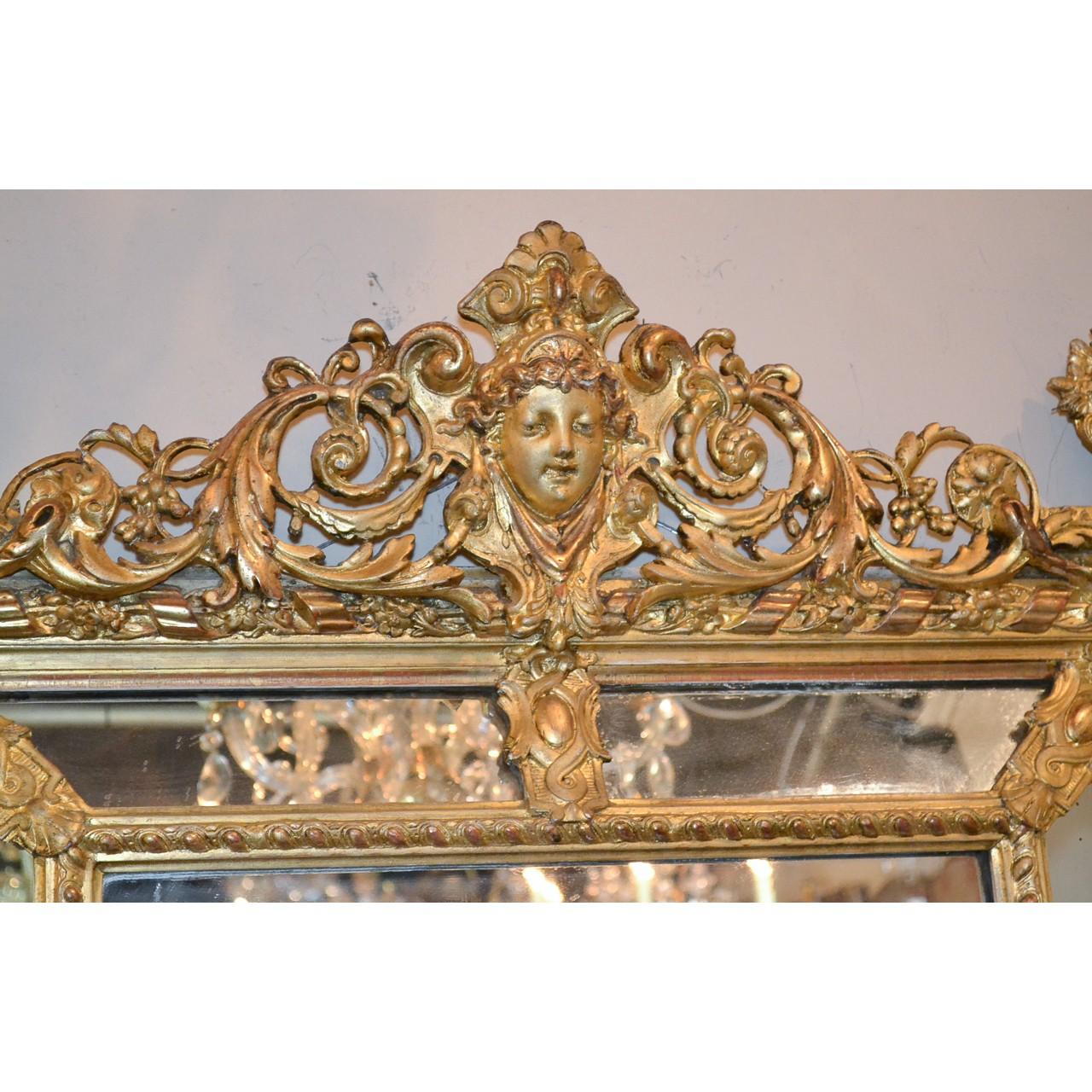Fine quality and very elegant 19th century French Louis XVI style giltwood cushion mirror. The superbly carved crest centred by a crowned caryatid masque carved in relief, and accented by reticulated leaf scrolls and berry clusters. The corners with