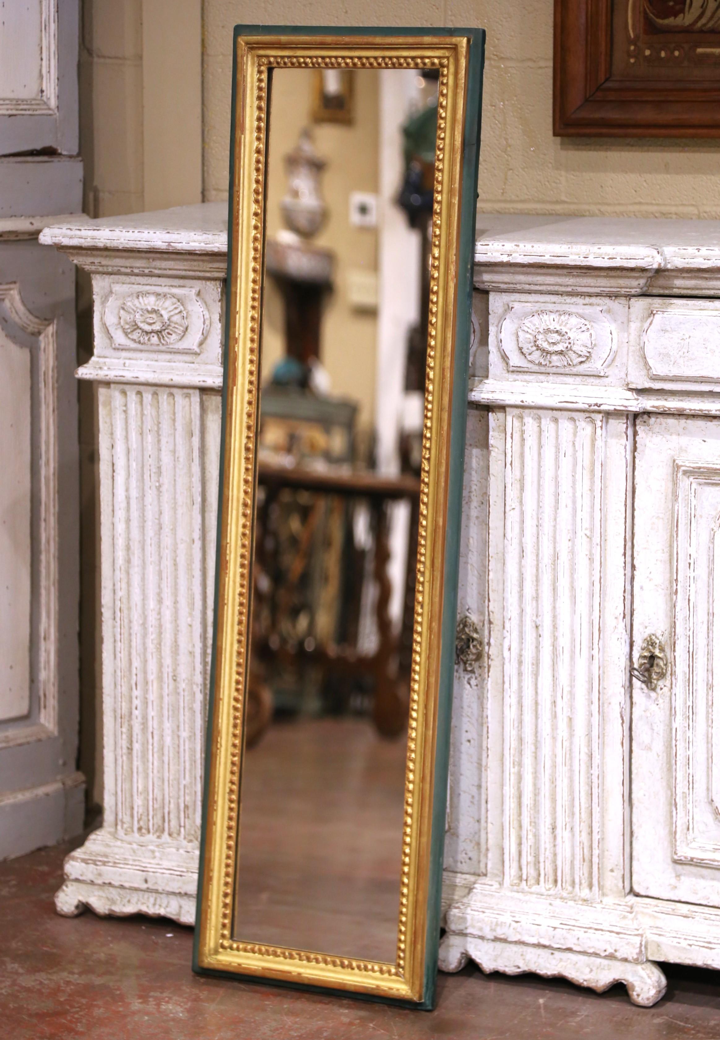 This antique French wall mirror was crafted circa 1870 in the Louis XVI style and features a refined combination of giltwood and painted surfaces. The molded frame is finished with a rich gold leaf along the inner edge, accented by a beaded trim,