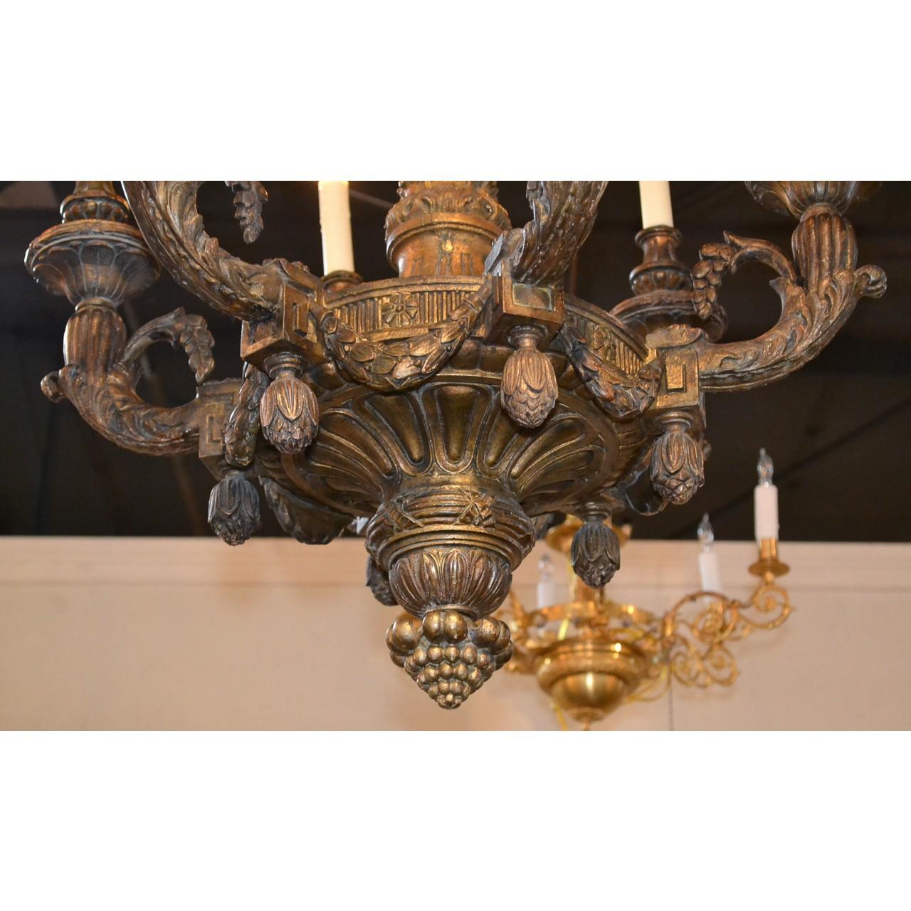 Understated 19th century French Louis XVI style duel-tone giltwood chandelier. The carved torch-shaped stem with twist-flutes and leaf tips leads to a finely carved circular centre with six branches accented with acanthus, thistle and berry swags,