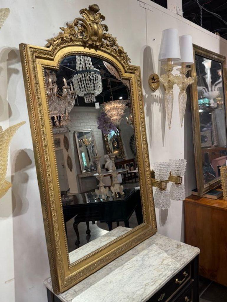 El espejo francés de madera dorada Luis XVI del siglo XIX es una impresionante pieza de decoración para el hogar que destila elegancia y sofisticación. Con su hermosa pátina y su intrincado diseño, este espejo destacará en cualquier habitación. El