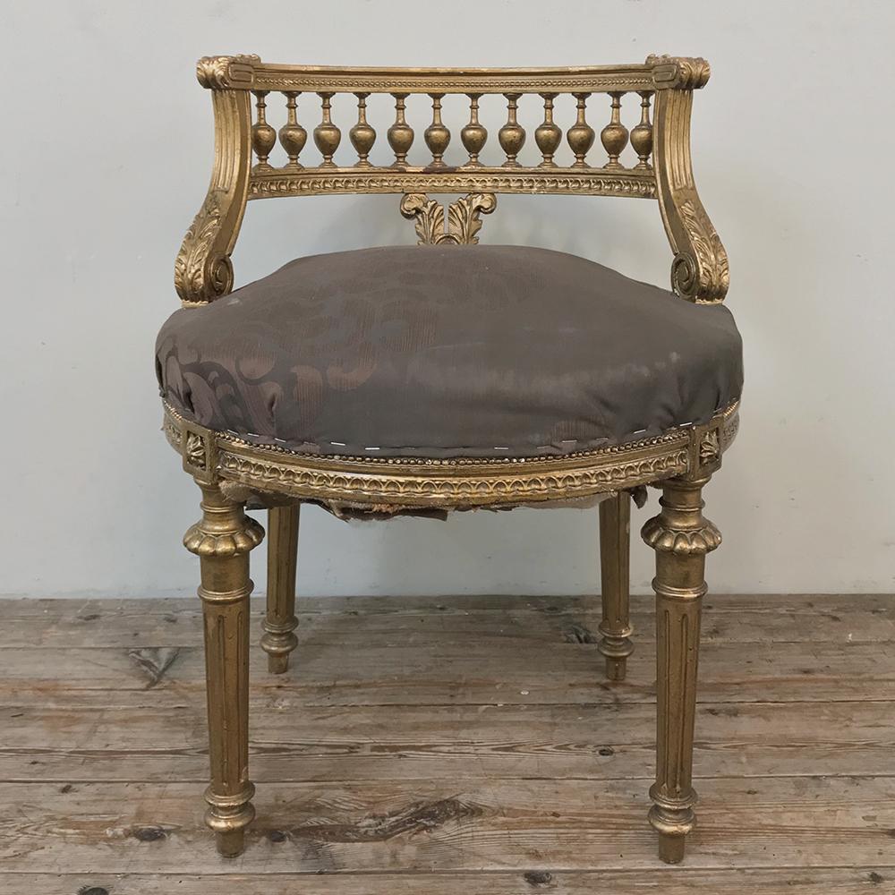 19th century French Louis XVI giltwood vanity chair represents the essence of the neoclassical movement, while providing an elegant seat for the bathroom, powder room or bedroom! Carved embellishments, spindle rail wraparound low seatback, and