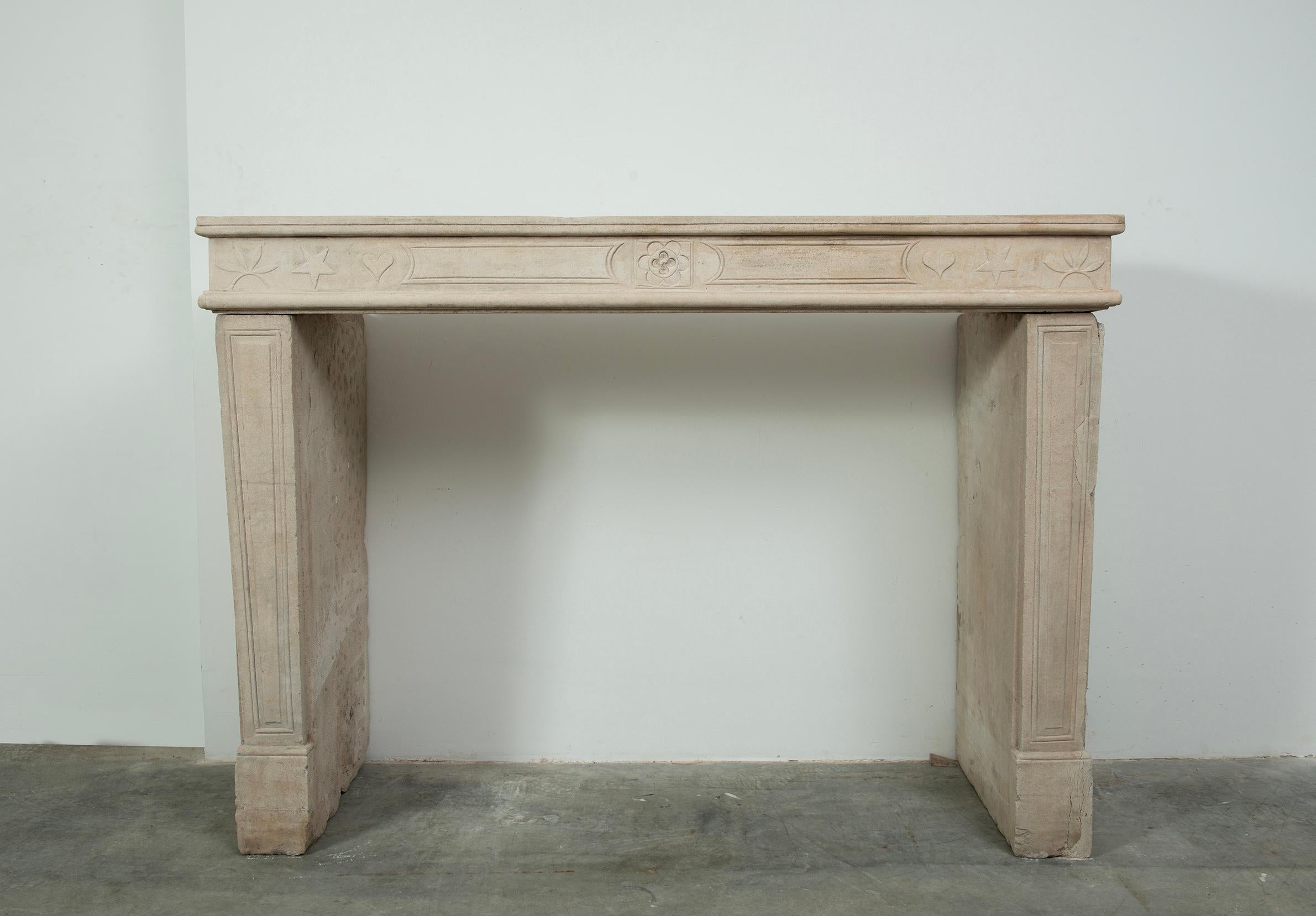 Add a romantic and refined touch to your space with this exquisite Louis XVI period fireplace mantel in hand-carved limestone, originating from 19th century France. Offered by SchermerhornAntique Fireplaces, this elegant piece is a rare find,
