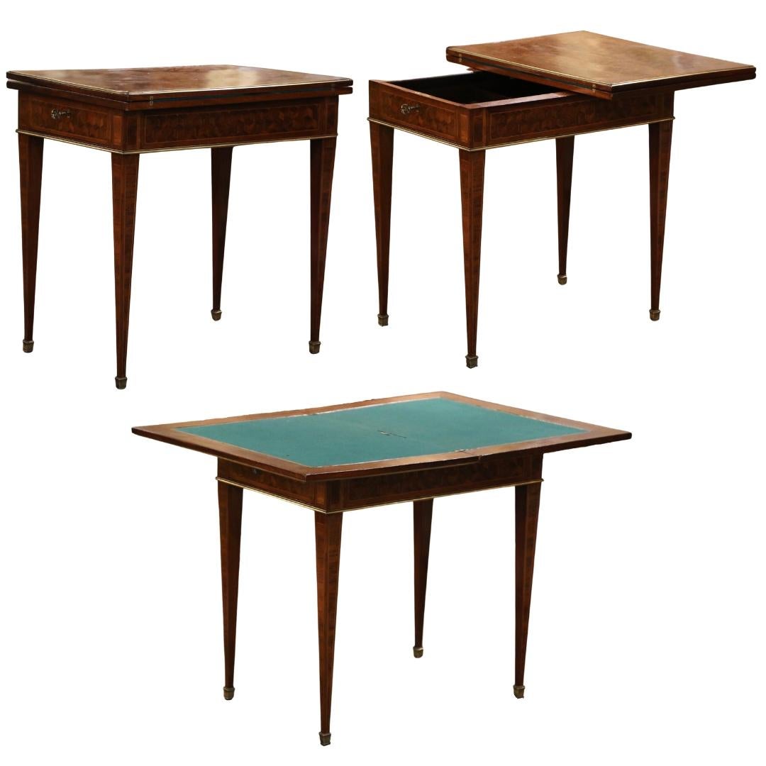 Decorate a game room or a den with this elegant folding card table. Crafted in France circa 1930 and built of mahogany wood with marquetry and inlay decor throughout, the rectangular table stands on tapered legs ending with bronze sabots feet over a