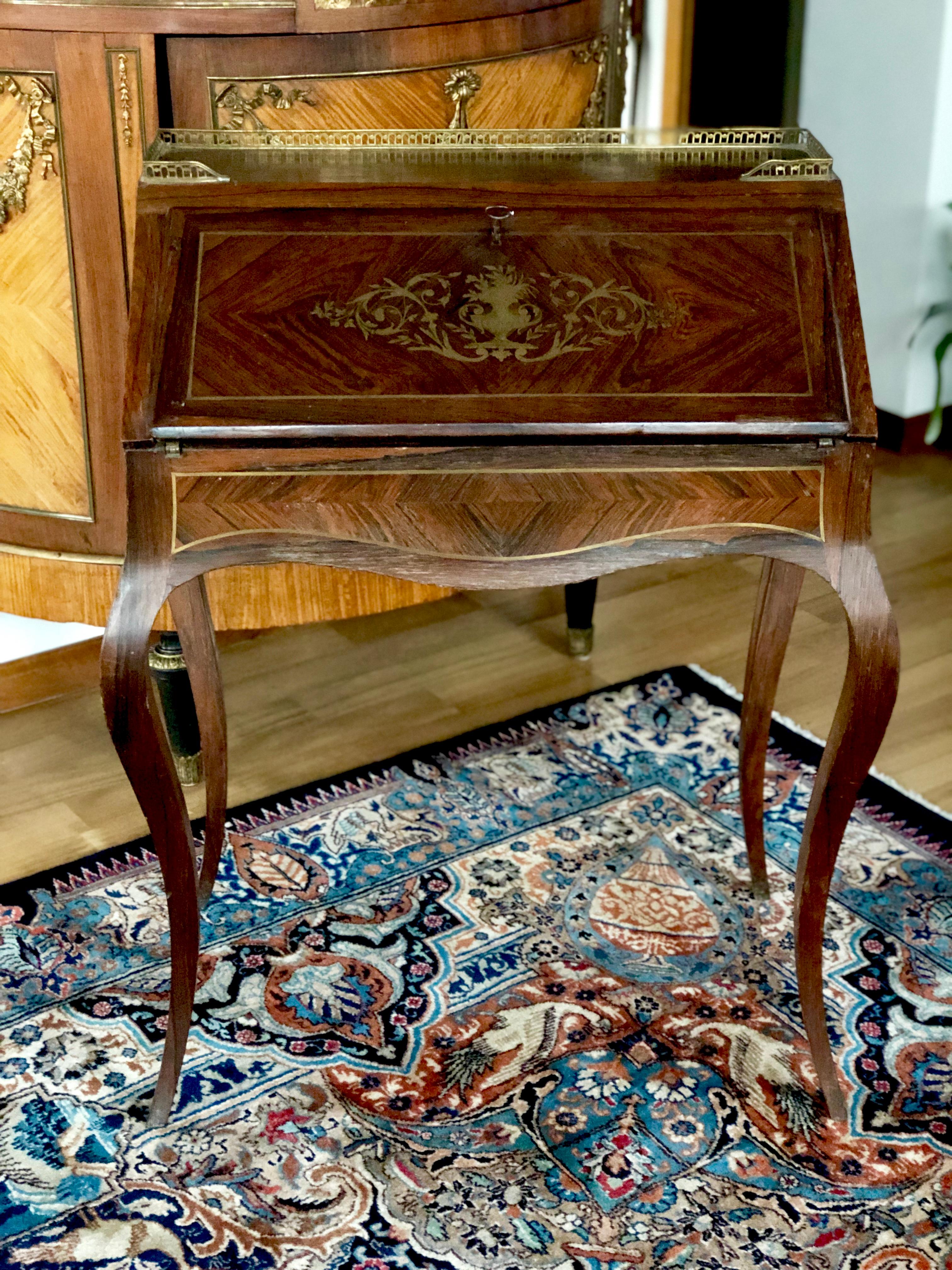 This is a beautiful antique French mahogany inlaid Ladies writing desk made circa 1890. The fall front opens to reveal an interior of leather writing surface, and bank of three drawers. The top has brass surrounding. The bureau stands on beautiful