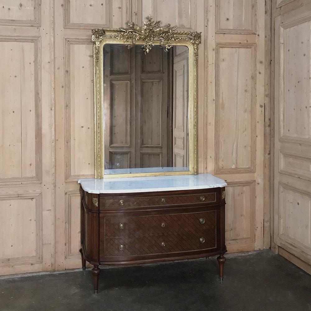 19th century French Louis XVI mahogany marble-top commode is an amazing example of the finest of craftsmanship from the Belle Epoque! Utilizing exotic imported mahogany, the artisans created a visual effect with inlay on the bowed facade, then