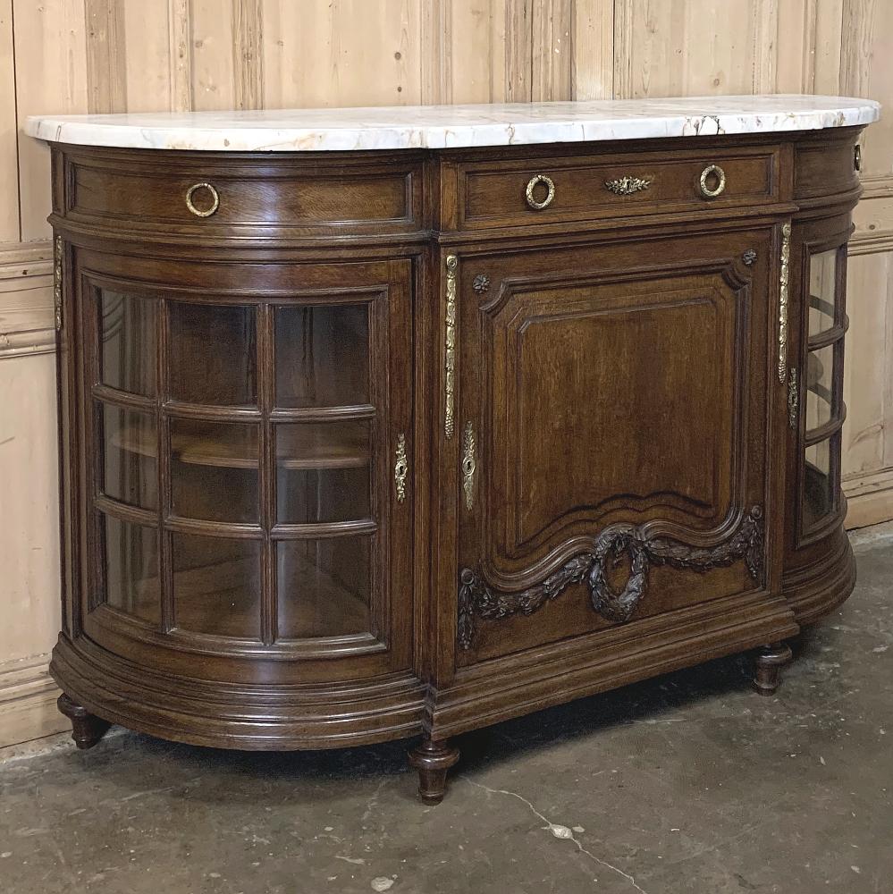 19th century French Louis XVI marble-top display buffet is an extraordinarily elegant rendition of the style, utilizing sumptuous old-growth French white oak stained a lovely walnut color to create exquisite sculpture on the lower section of the