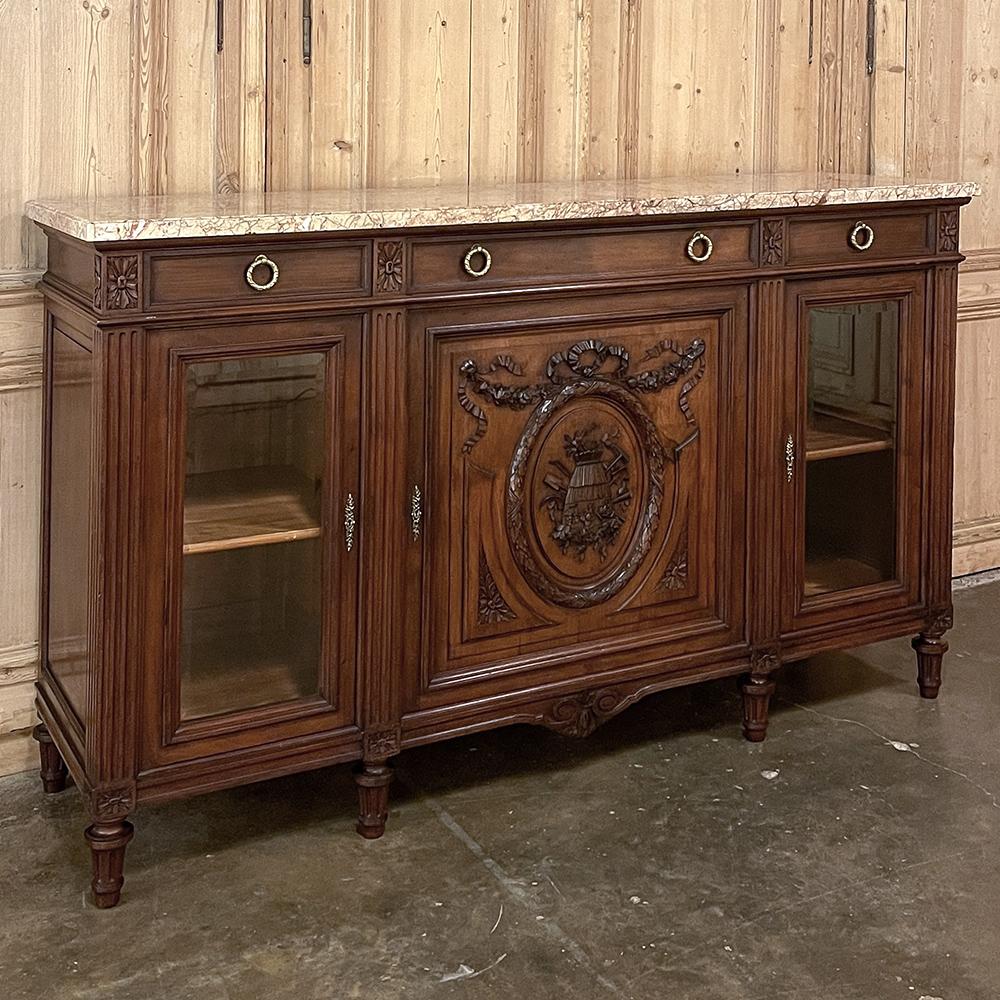 19th Century French Louis XVI Marble Top Display Buffet was hand-crafted by master artisans from indigenous French walnut, luxuriously veined Sienna marble, hand-cast bronze and beveled glass to create a truly special one-of-a-kind look that serves