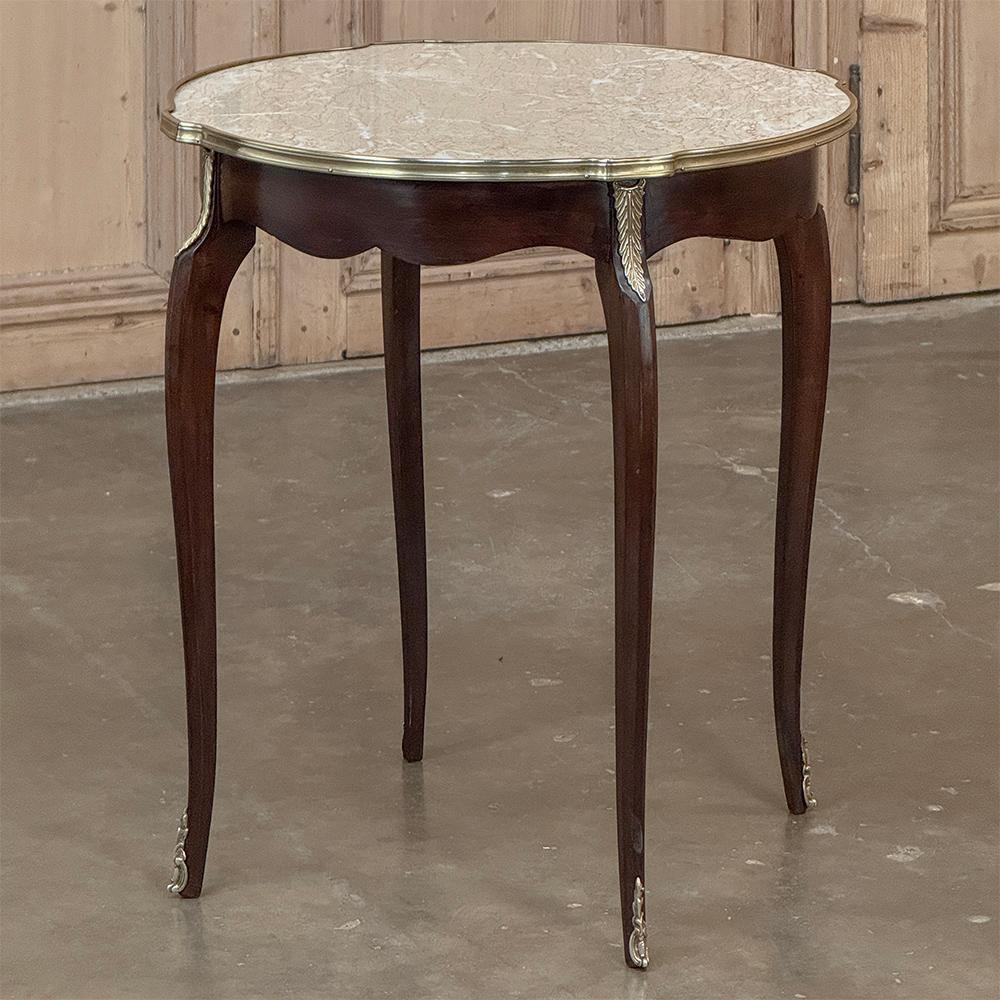 Cette table d'appoint à plateau de marbre Louis XVI du XIXe siècle a été habilement fabriquée en acajou exotique importé, puis ornée de montures en bronze coulées à la main sur les pieds, les épaules des pieds, et enfin dotée d'une moulure en laiton
