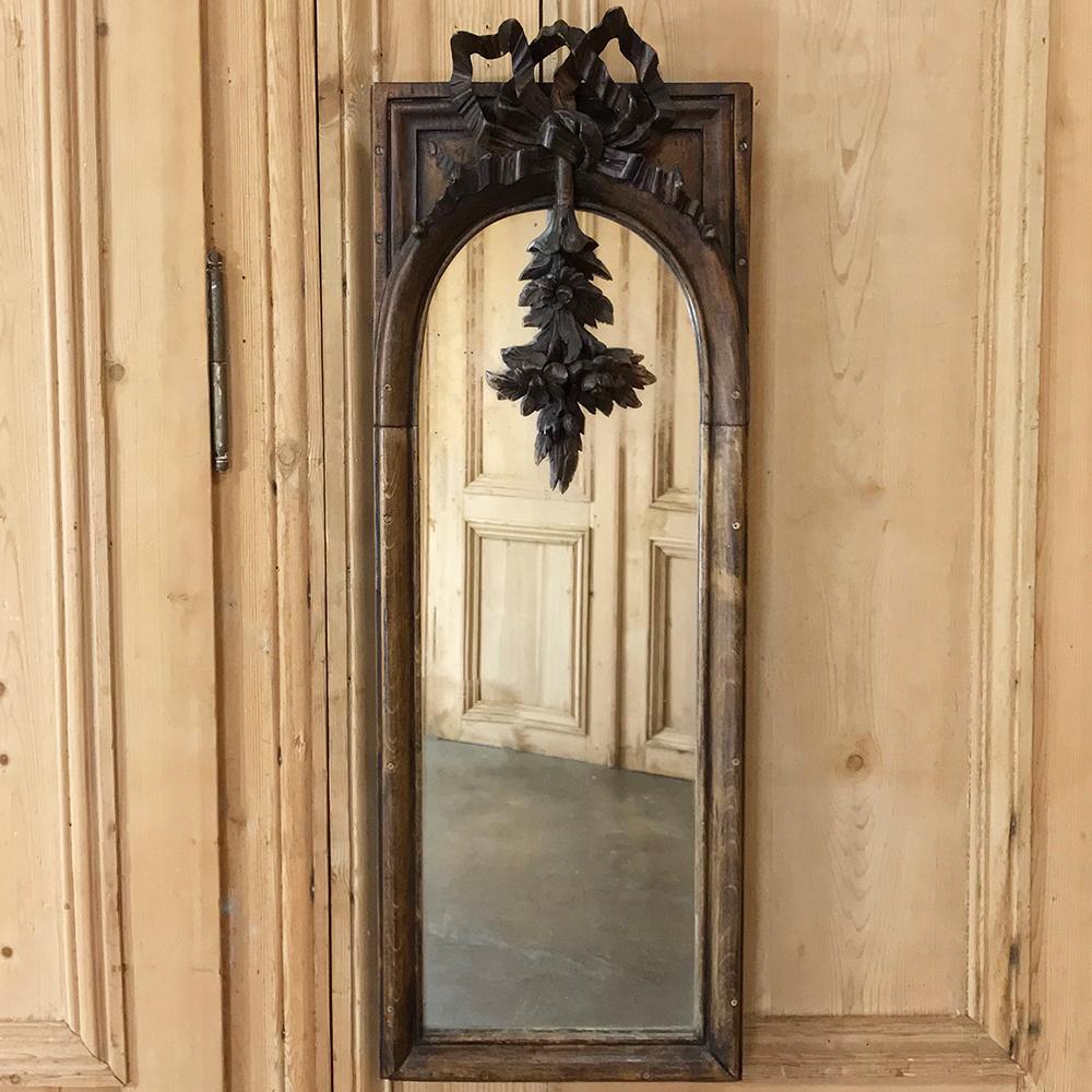 19th century French Louis XVI Mirror is a narrow design ideal for powder rooms, niches, or dressing areas. Elaborate ribbon and bow motif and arched mirror create a timeless neoclassic look,
circa 1870s
Measures: 35.5 H x 12.5 W.