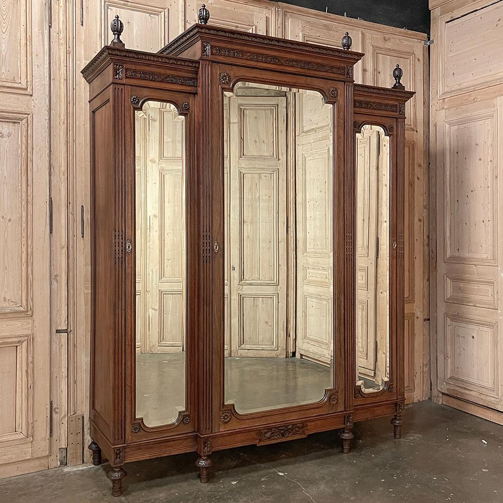 19th Century French Louis XVI Neoclassical Triple Walnut Armoire represents the epitome of understated timeless elegance!  Hand-crafted and sculpted from sumptuous French walnut, it features a step-front center cabinet flanked by two recessed side