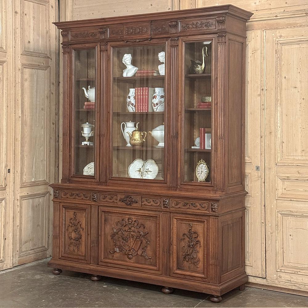 La libreria tripla in noce neoclassica francese Luigi XVI del XIX secolo è un esempio superlativo dell'arte dell'ebanista!  I talentuosi artigiani hanno utilizzato il sontuoso noce francese per creare un grande mobile con tre ante vetrate con vetro