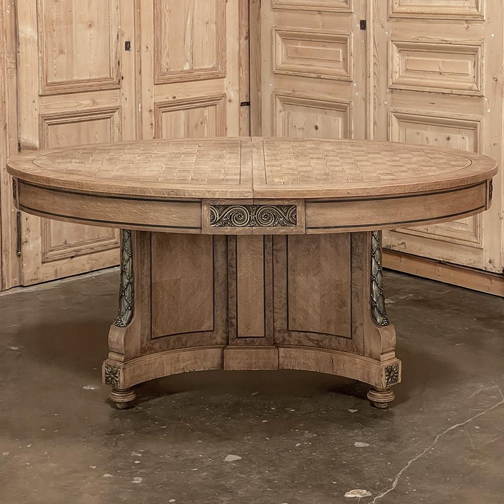 19th Century French Louis XVI oval parquet dining table with ormolu is a study in Neoclassical elegance! Utilizing solid oak and oak checkerboard parquet for the top, the artisans also employed the signature French bordering in dark heart walnut