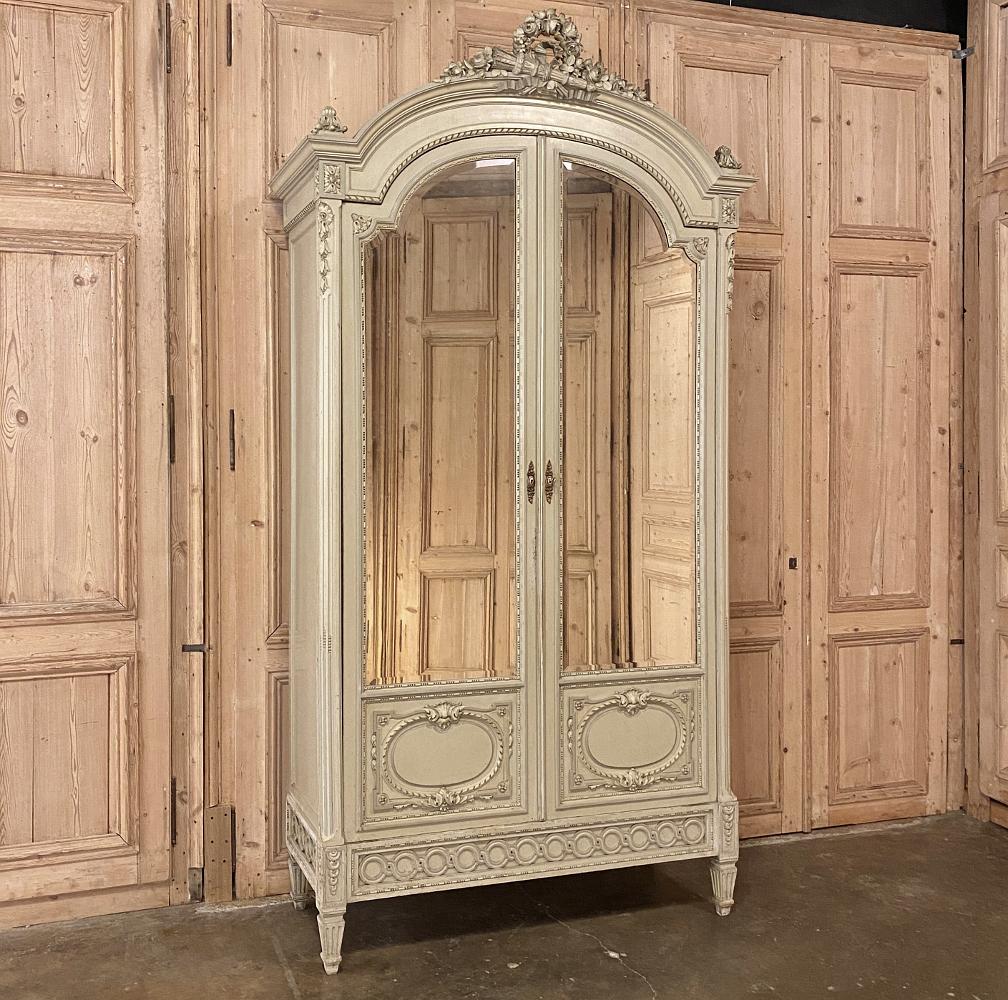 19th century French Louis XVI painted armoire represents the epitome of Parisienne elegance! Handcrafted by expert artisans using time-honored techniques, it exhibits the essence of the classical style, from the boldly arched crown above to the