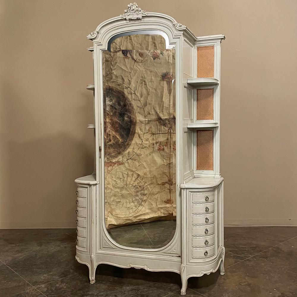 Cette armoire peinte de style Louis XVI du 19e siècle est une splendide combinaison de style, de forme et de fonction ! Le miroir biseauté à la main sur toute la longueur de la porte offre un joli reflet de votre pièce et sert de miroir d'habillage