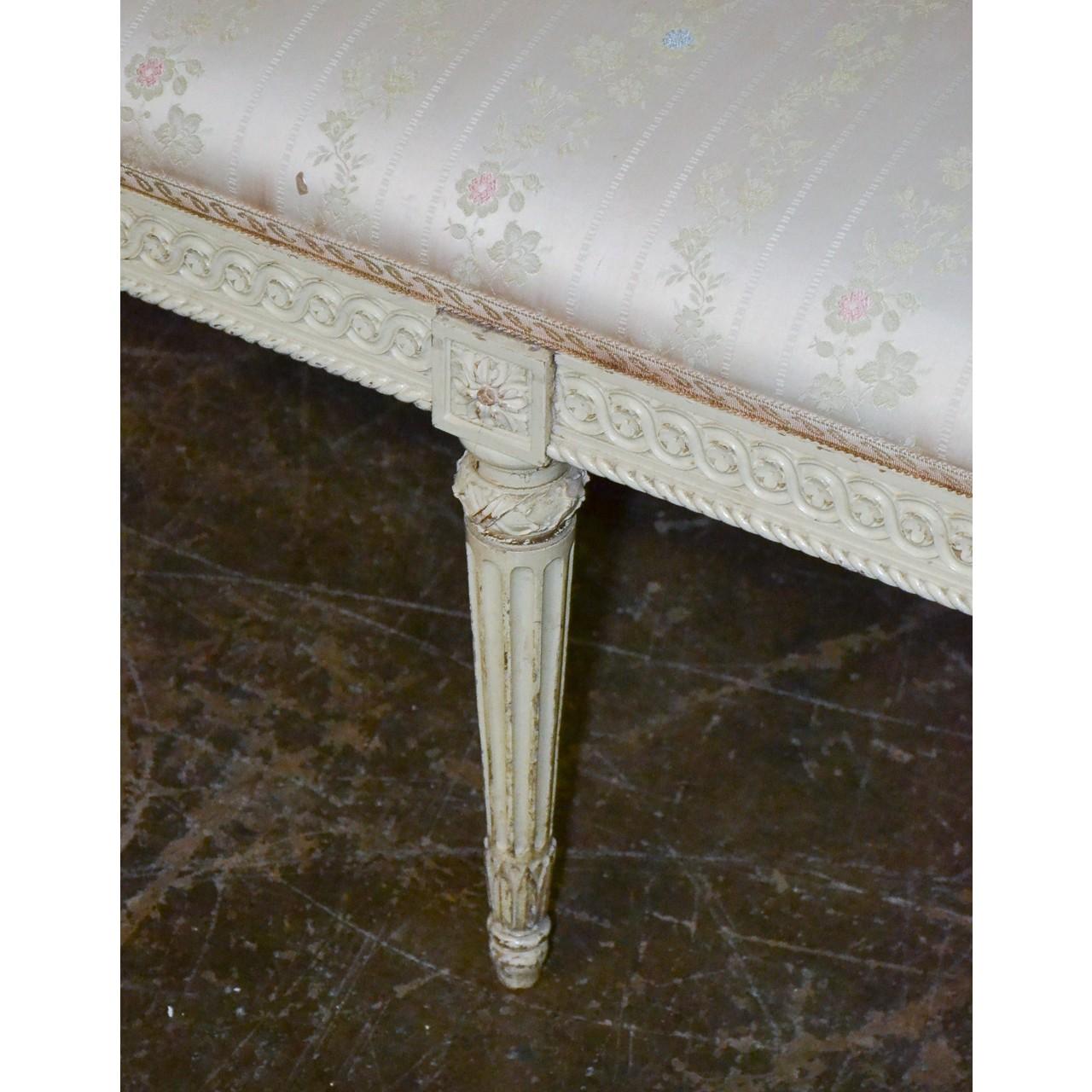 Gorgeous 19th century French Louis XVI style painted bench. Finely carved with stylized trim and flower heads. On sleek tapered and fluted legs. Damask upholstered top,

circa 1870.