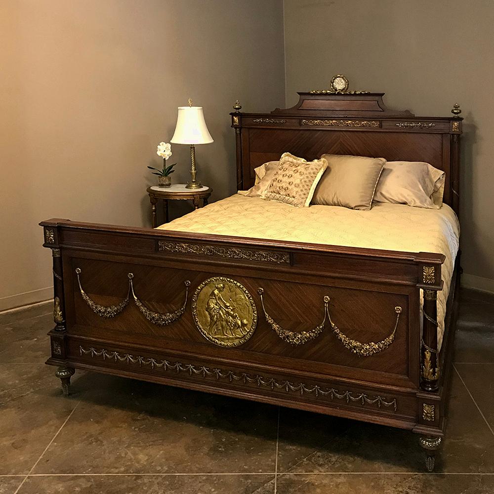 19th century French Louis XVI Queen bed with ormolu mounts is a spectacular example of the height of artistry from the Belle Epoque in France! A Wedgwood plate is mounted inside the bronze laurel wreath with laurel sprays that appears centered on