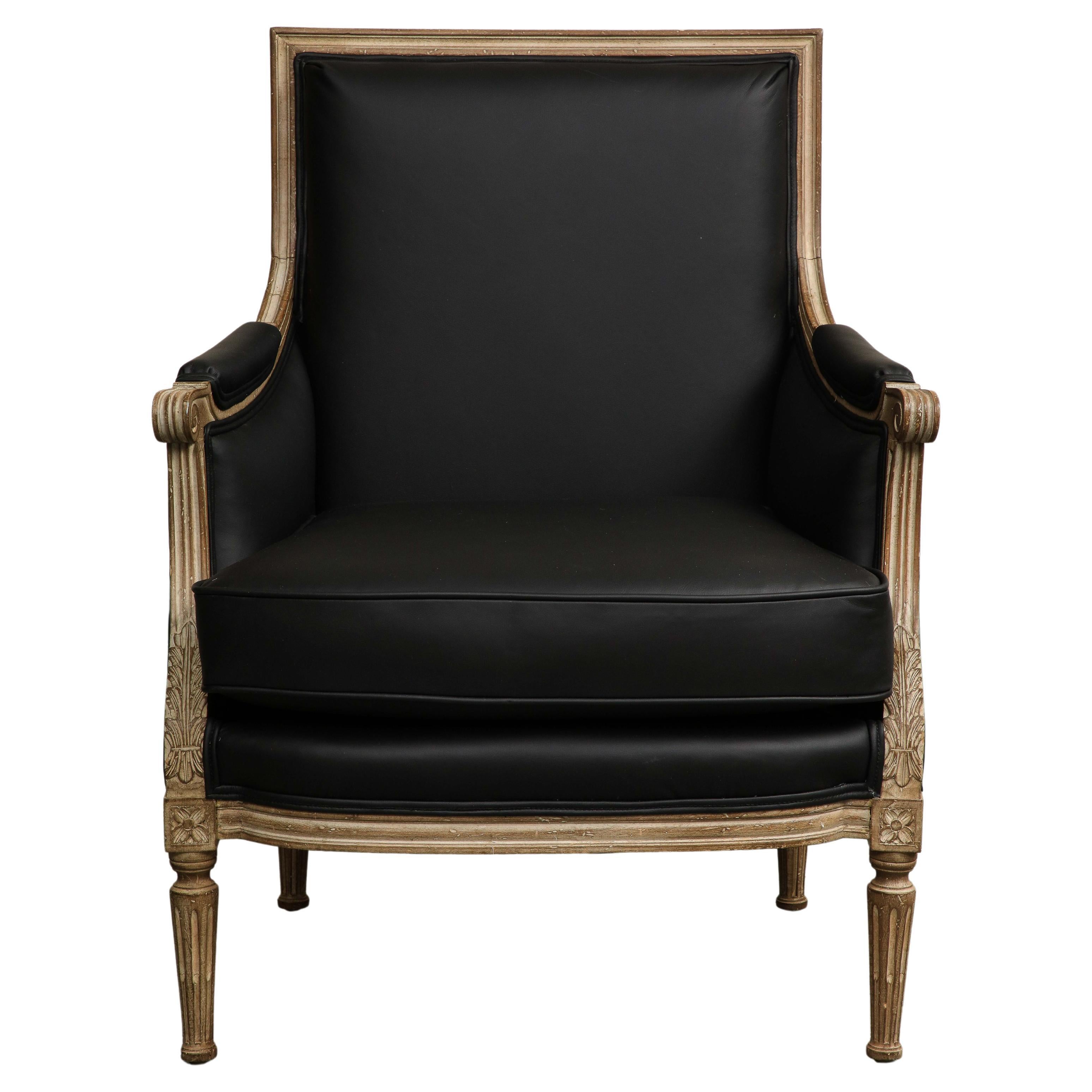19th Century French Louis XVI Style carved and painted wood Bergère armchair. Black leather upholstery newly redone in 2022, including seat, back and arm rests. 

Dimensions: 
37