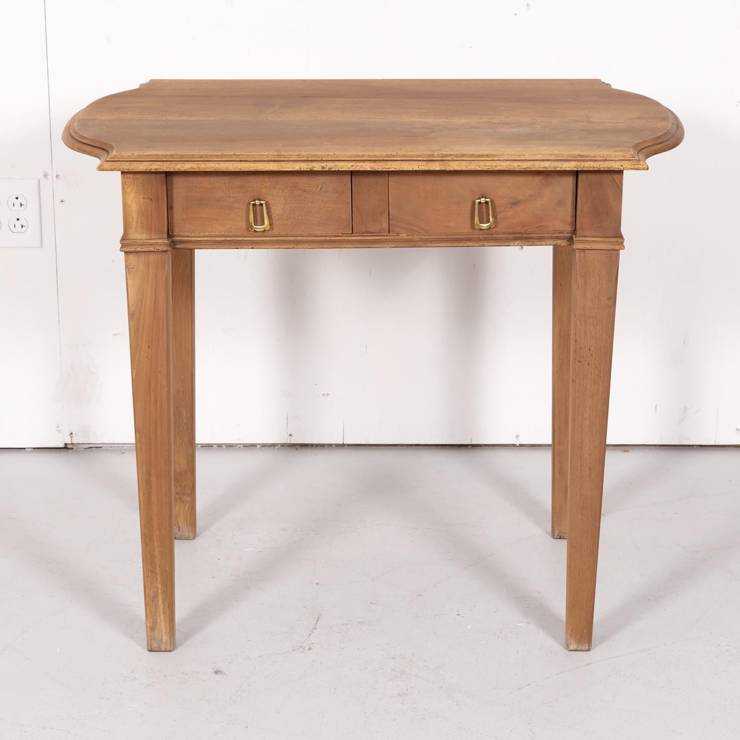 A 19th century French Louis XVI style side table handcrafted in Lyon of solid walnut, circa 1880s, having a bleached finish with a shaped top over two drawers. Raised on tapered legs.

Dimensions:
H 29.5